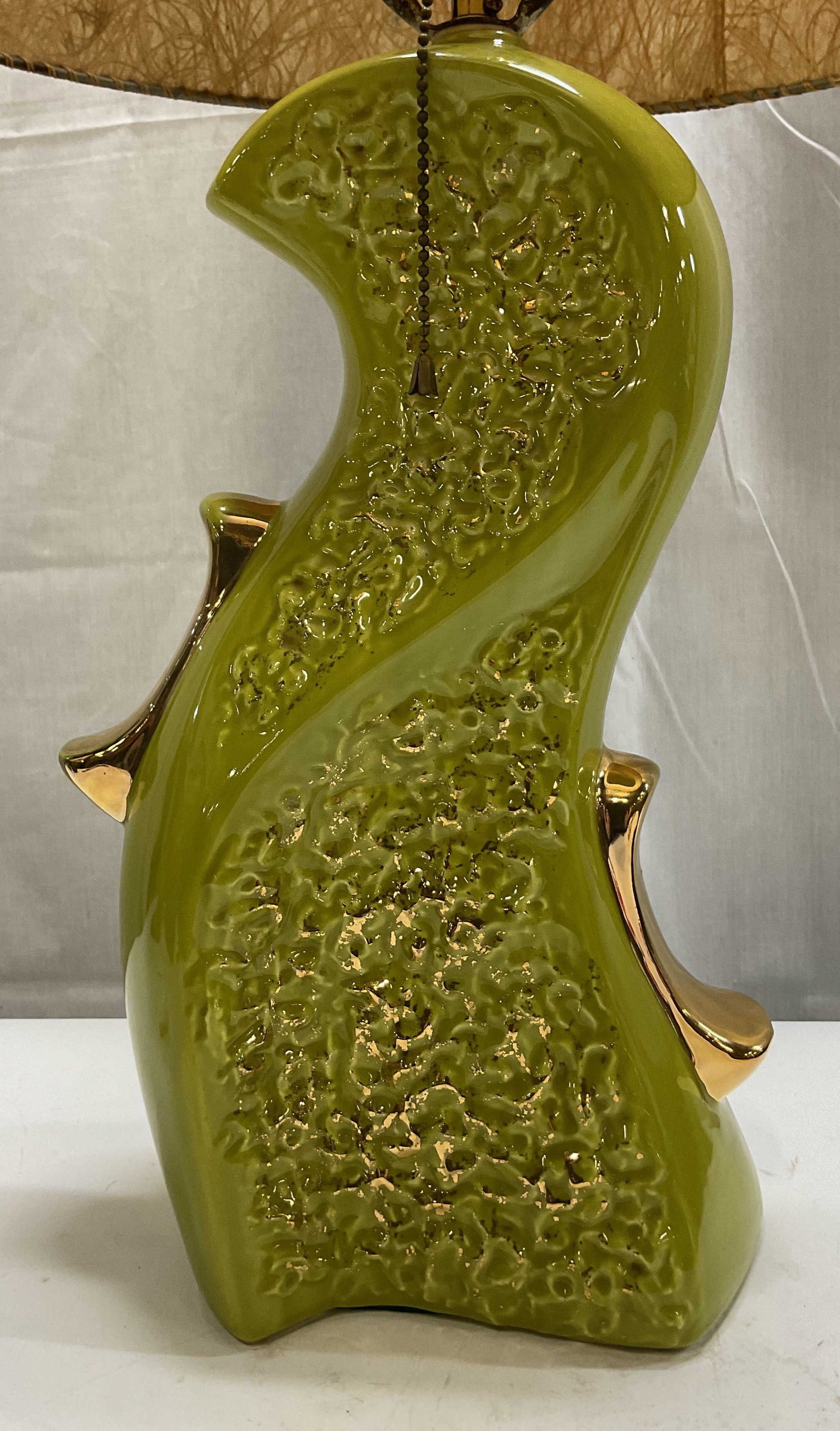 MCM Chartreuse Ceramic Table Lamp W Shade: Mid century modern chartreuse ceramic table lamp. Comes with brown textured shade. Textured surface with gilt accents. Abstract unique shape. Glossy finish. Measures approx 6 x 7 x 26.5 inches. Not te