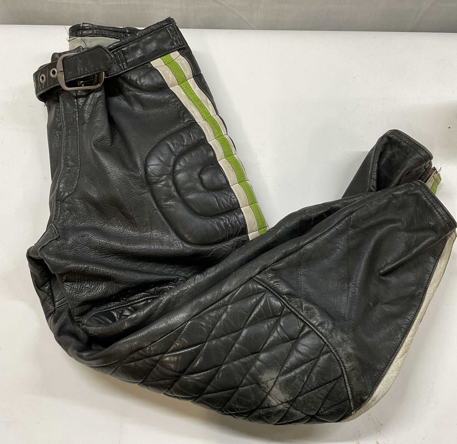 Vntg KAWASAKI heavy leather racing pants , 1970s: Vintage KAWASAKI heavy leather racing pants. Made during the 1970s from genuine leather in size 40. Features the iconic Kawasaki green and white racing stripes down the sides. Built with ultra thick t