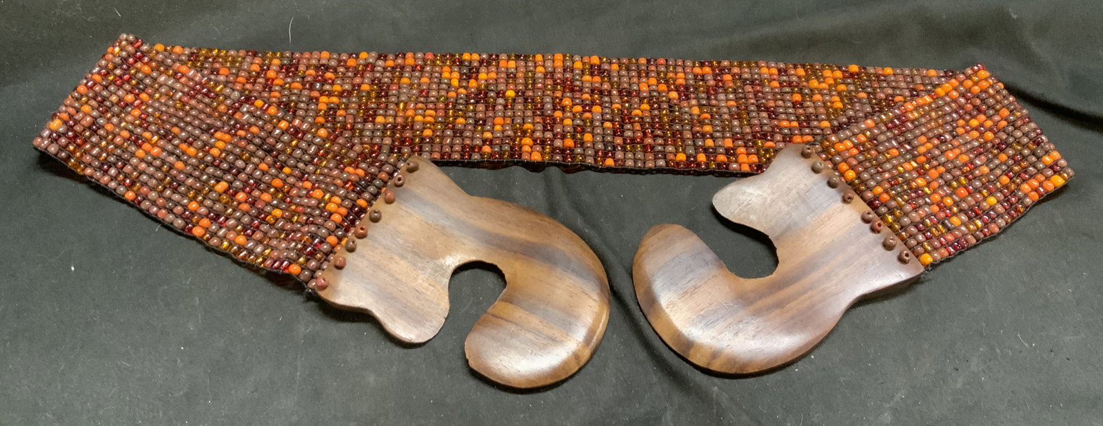 Vintage C1970s Beaded Stretch Belt: Vintage Circa 1970s Beaded Stretch Belt. Multi-Strand woven seed beads in an earth-tone Autumn palette. Interlocking carved wooden hook buckle. Multi-Strand woven seed beads. Condition consistent with