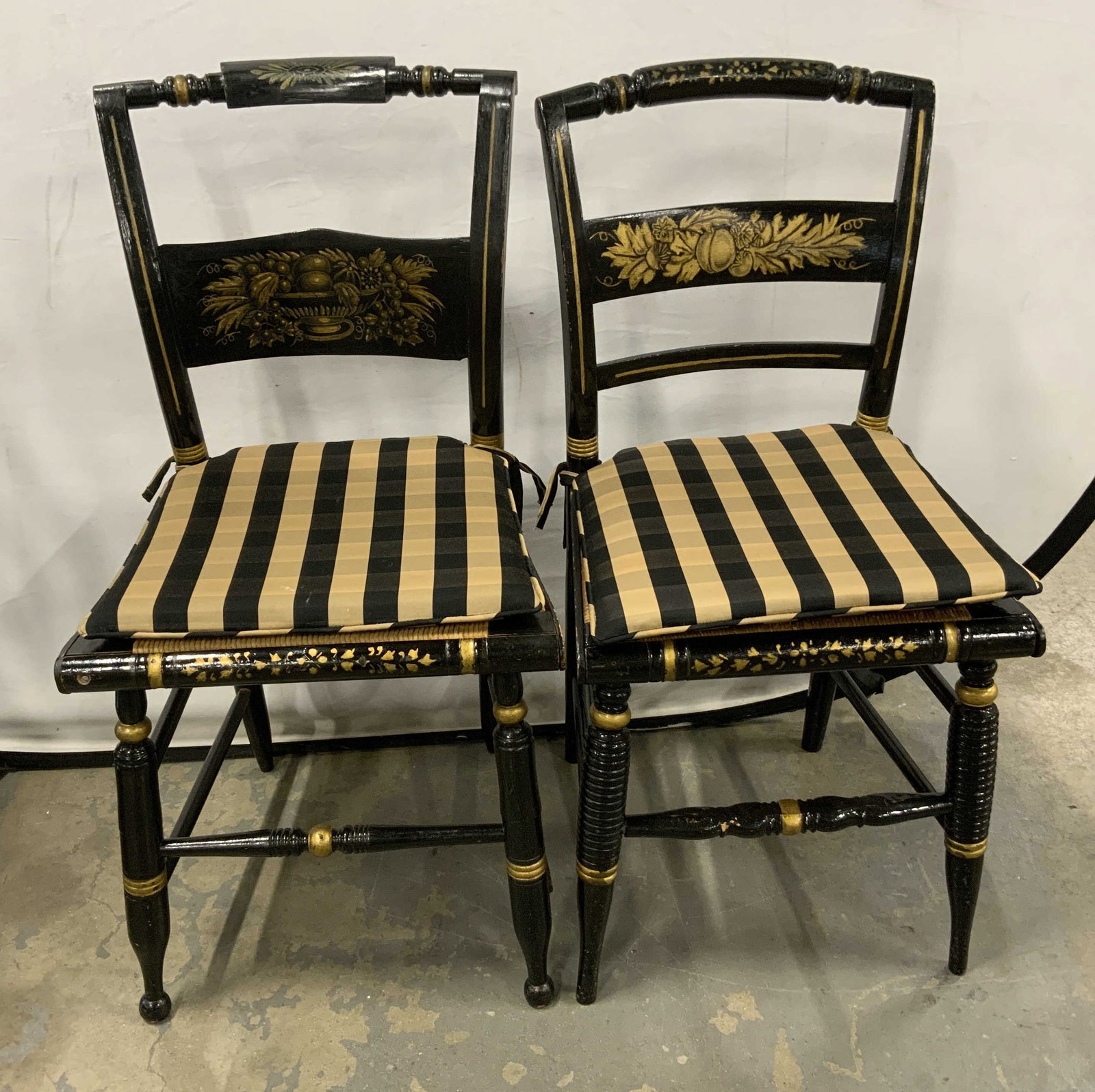 Set 2 Black Gold Wood Hitchcock chairs: Black and gold vintage possibly antique pair Hitchcock side chairs, or Sheraton revival painted furniture, each has rush seat comes with striped tie on upholstered seats, crest rails have gold leaf st