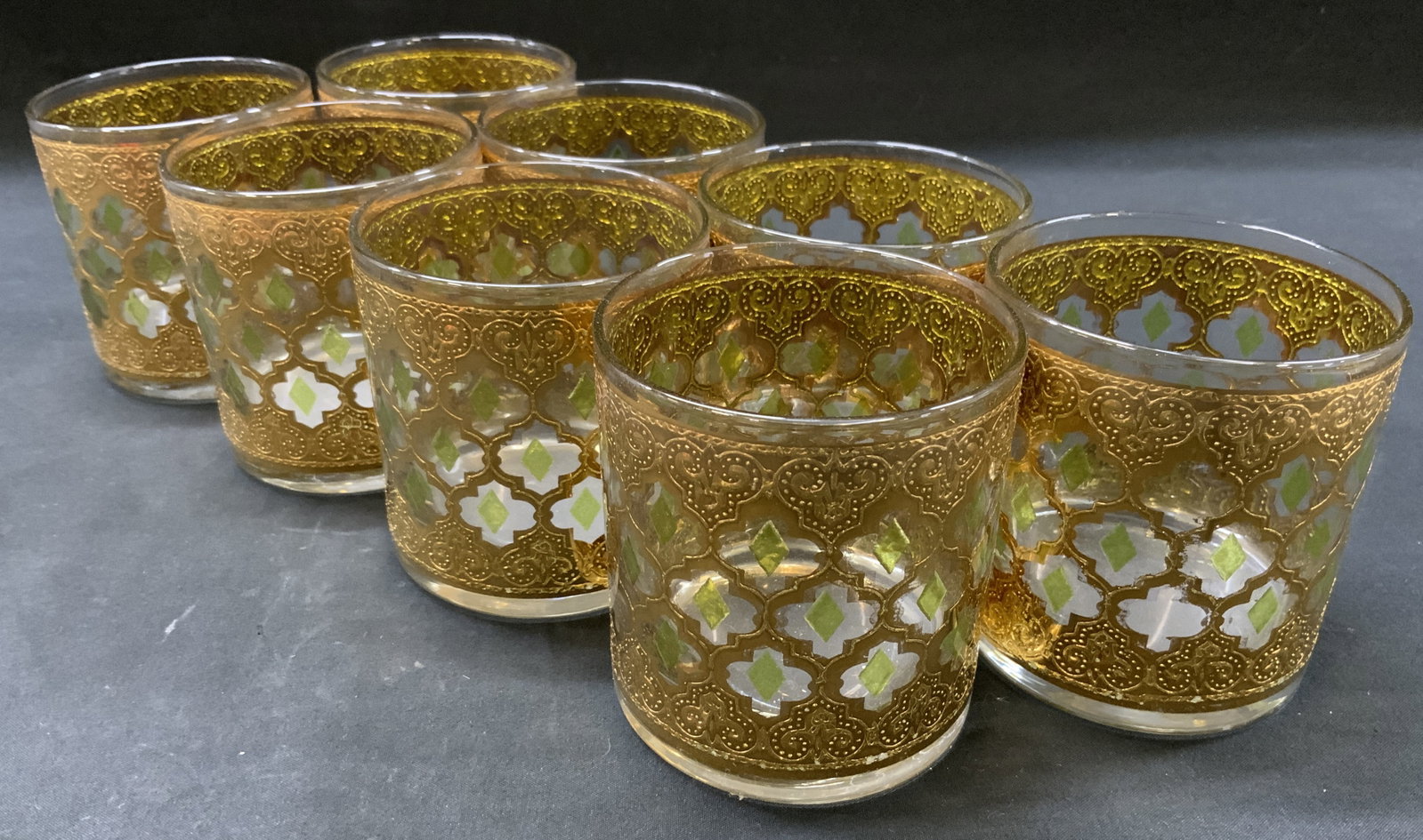 Vtg Lt8 Culver Valencia 22k Gold Glass Tumblers: Mid century vintage set of 8 glass tumblers. Styled in Valencia pattern. Moroccan inspired lattice trellis embossed with 22k gold filigree. Accented with green diamonds. Circa 1960s. Condition consist