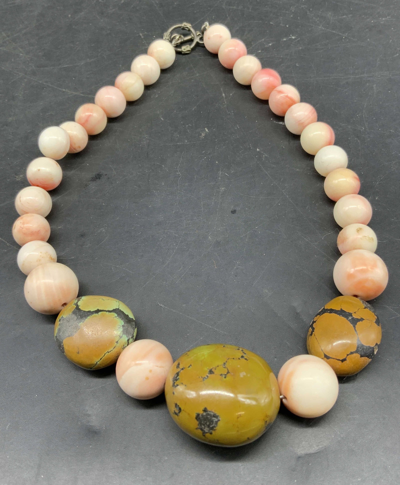 Angel Skin Coral w yellow green turquoise Necklace: Chunky vintage statement necklace composed of large gemstone beads and silver toggle clasp, specifically the large focal beads are large mustard green yellow turquoise stones and the graduating soft p