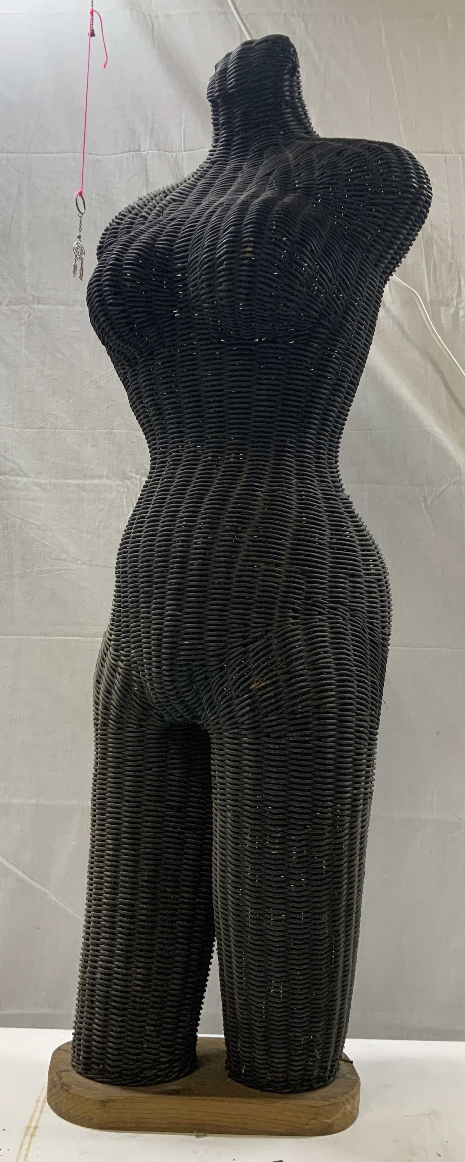 Vntg woven wicker female mannequin torso: Vntg woven wicker female mannequin torso. Dark black woven wicker and rattan female mannequin body form with upper legs mounted on a small wooden base. Vintage style bohemian or retail display piece.