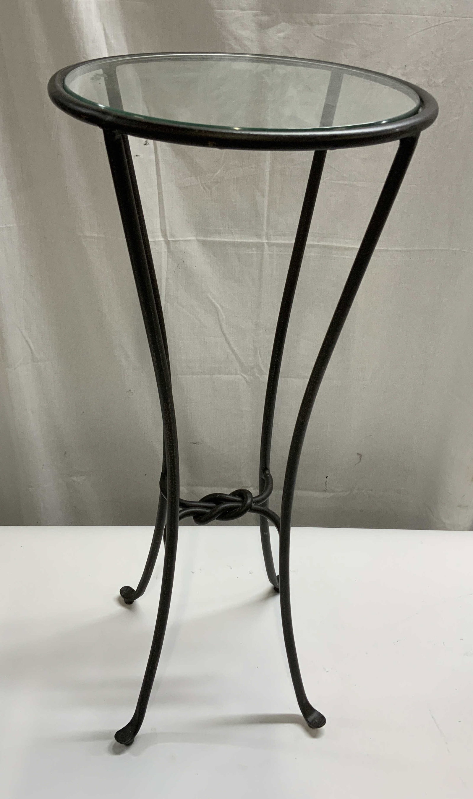 Black Hammered Iron Glass Top Table: Hammered Iron and Tempered Glass Top Table. Black and brown speckled Finish. Knotted design on base. Condition consistent with age and exposure. Measures app 28in H x 8.5in W x 12in Diam. metal