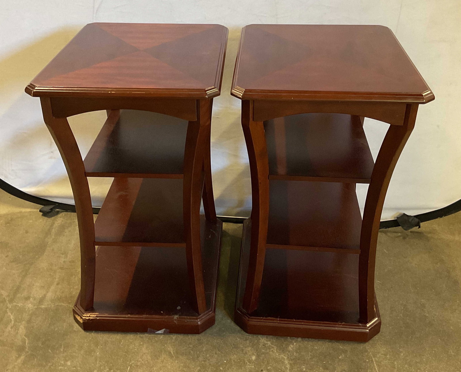 Pair Late 20thC Mahogany 4 Tier Side Tables: Pair of late 20th century wooden mahogany four tier side tables. Geometric pattern on top. Top surface and three lower open display shelves. Curved side supports. Measures approx 15.5 x 20 x 27