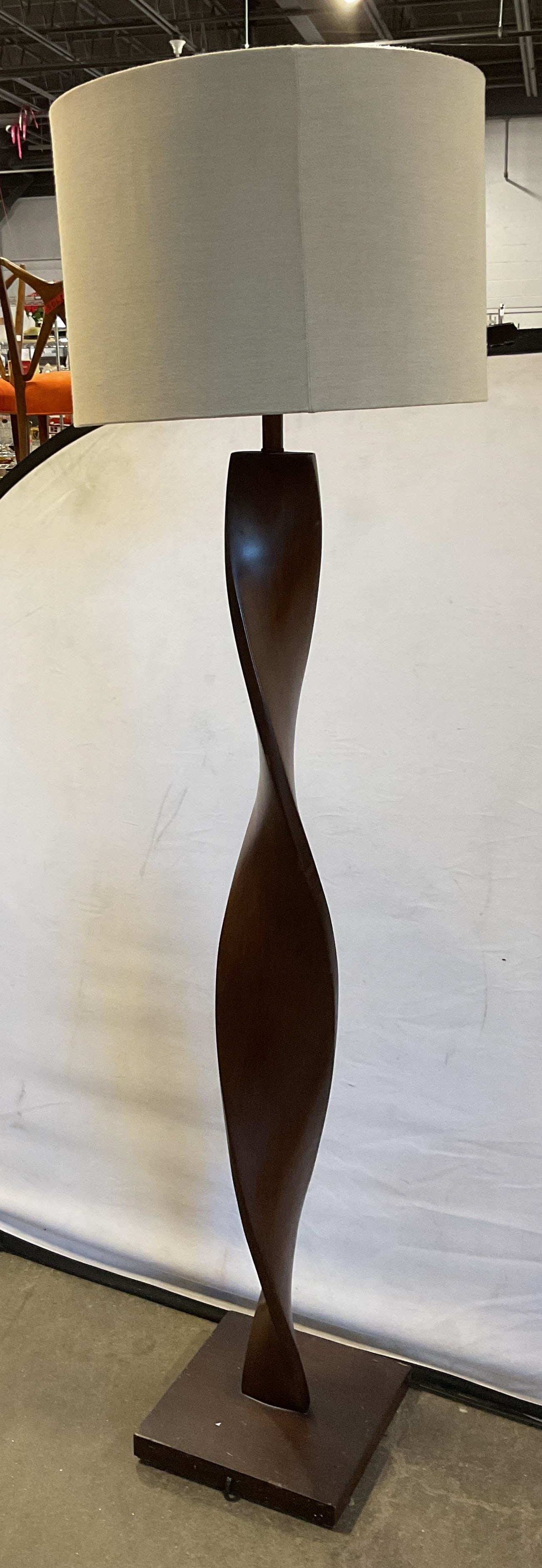 Pier 1 Twisted Wooden Floor Lamp W Shade: Pier 1 twisted wooden floor lamp. Comes with cream colored drum shade. Sculptural twisted shaft with square base. Dark wooden tone. Measures approx 11 x 11 x 62 inches. Not tested for function, sold