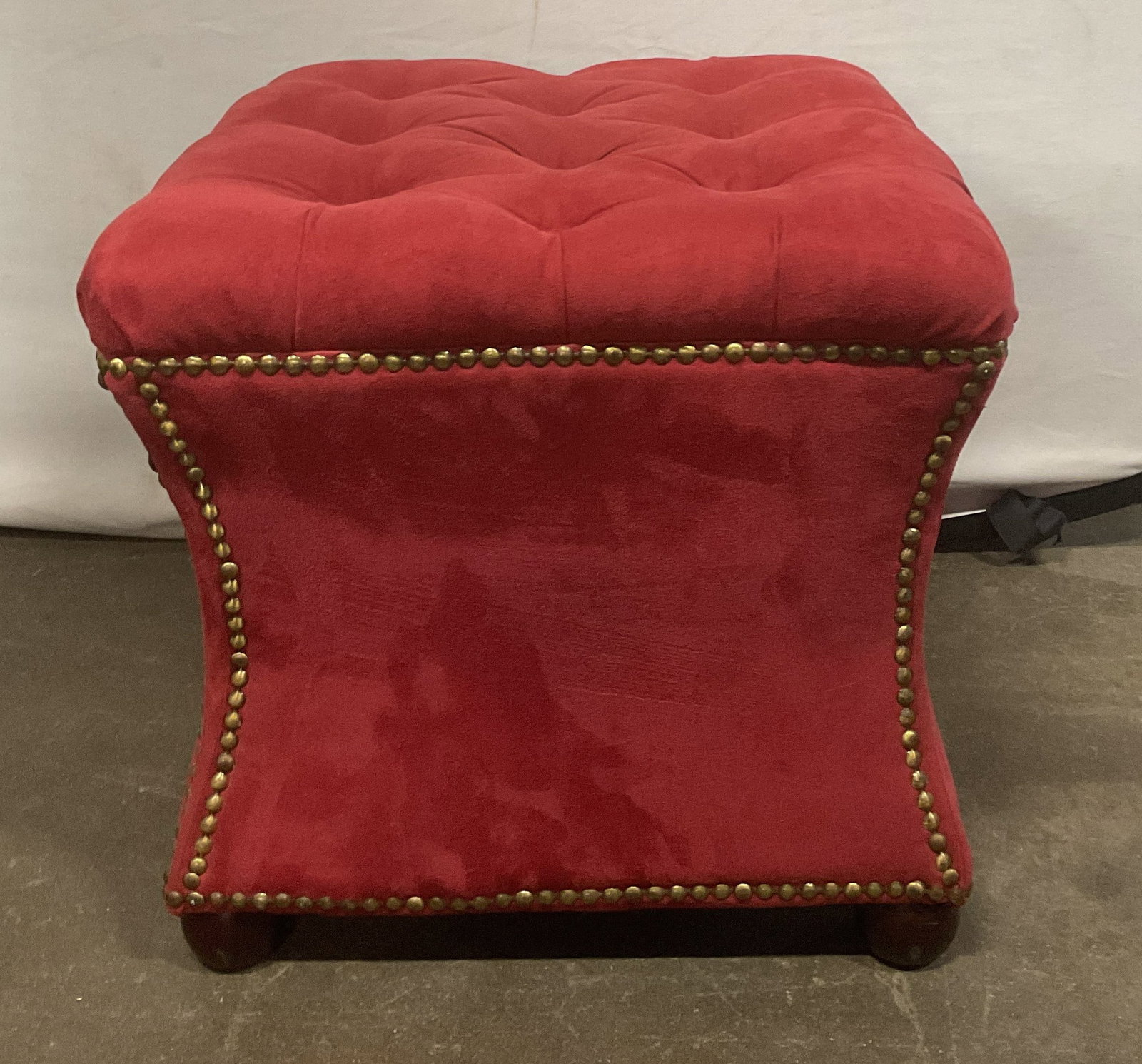 Vtg Red Suede Style Tufted Nailhead Ottoman: Vintage red suede style tufted nailhead ottoman. Suede style, possibly velvet. Top cushion has classic diamond pattern with deep buttons pressed into the fabric. Brass nailhead trim. Body curves