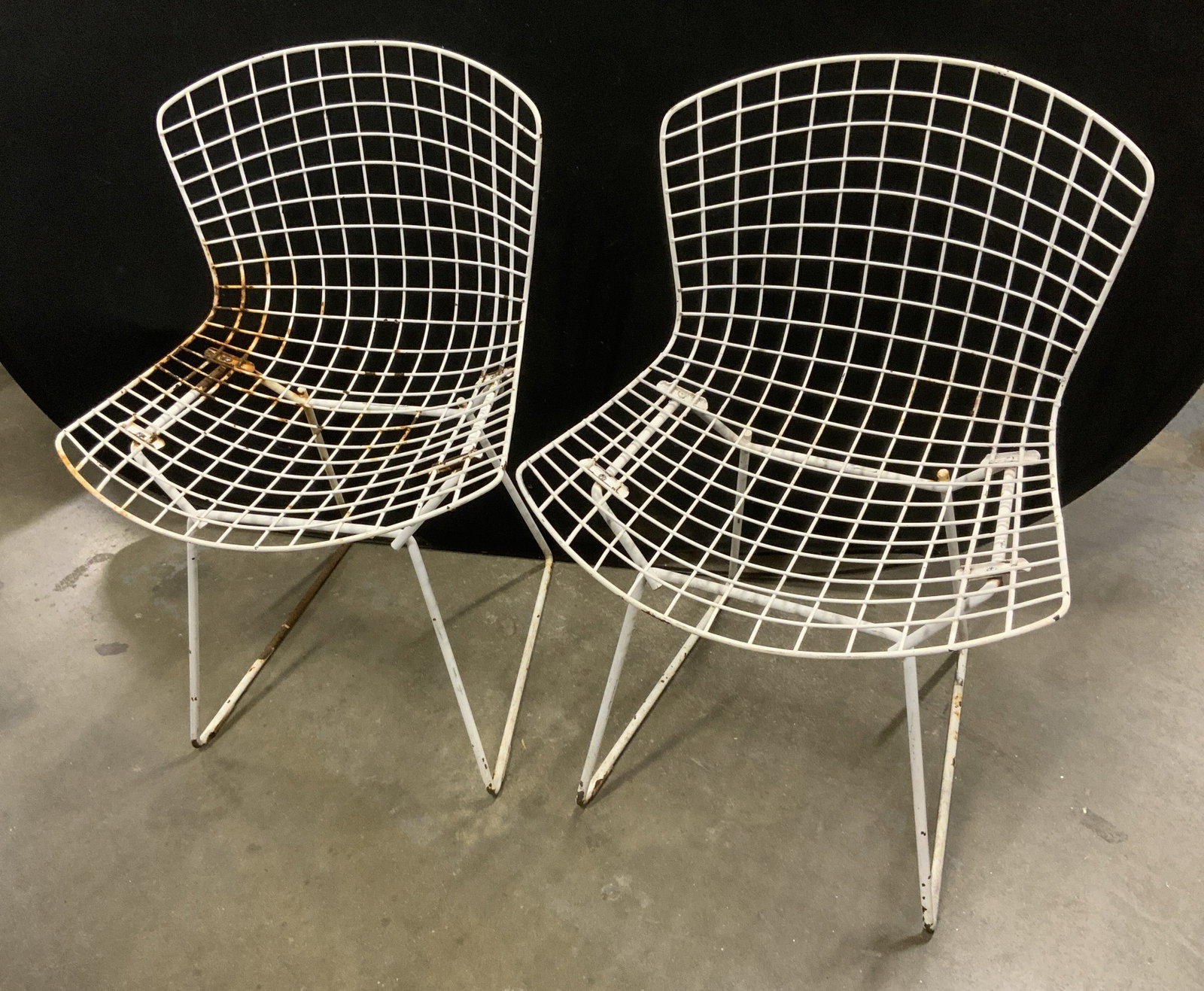Pr Harry Bertoia Style Welded Steel Wire Chairs: Pair of White Welded Steel Wire Chairs. Lightweight. Vinyl coating. In the style of designer Harry Bertoia for Knoll chairs in the 1950s. Aging to metal present. Measures app 30in H x 19in L x 14in