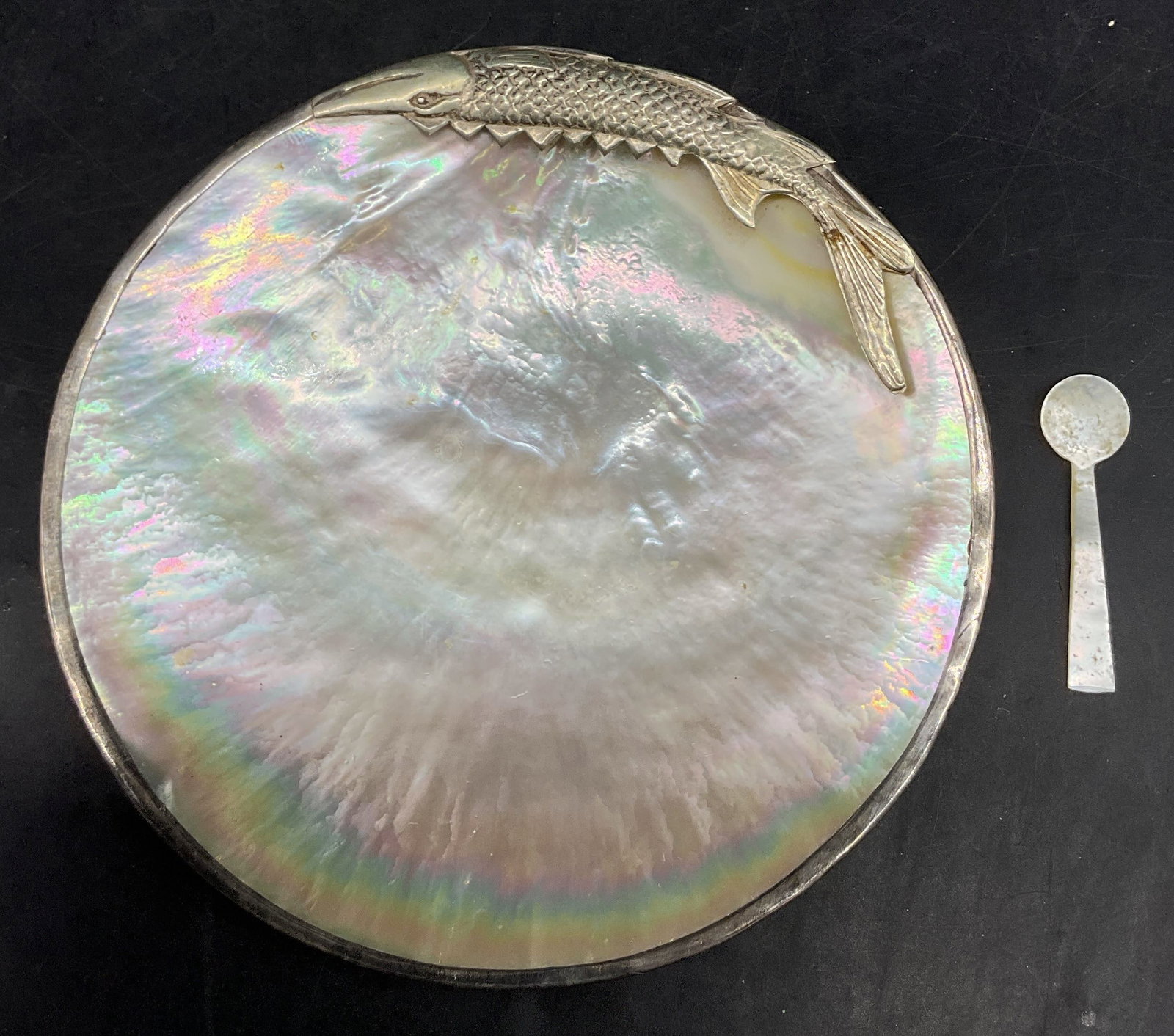 Vtg Sterling Silver Mother Of Pearl Caviar Dish: Vintage sterling silver mother of pearl caviar dish. Comes with matching small spoon. Surface marked Sterling. Iridescent mother of pearl bowl. Sterling trim featuring a sturgeon fish. Textured