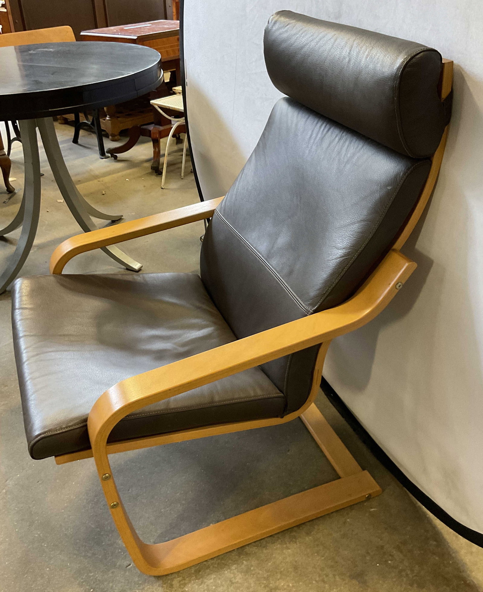 IKEA Poang Wooden Armchair Romania: IKEA Poang wooden armchair. Made in Romania. Curved wood frame and curved armrests. Dark brown leather seat cushion. Tall backrest with built in headrest pillow. Measures approx 19 x 27 x 38 inches. S