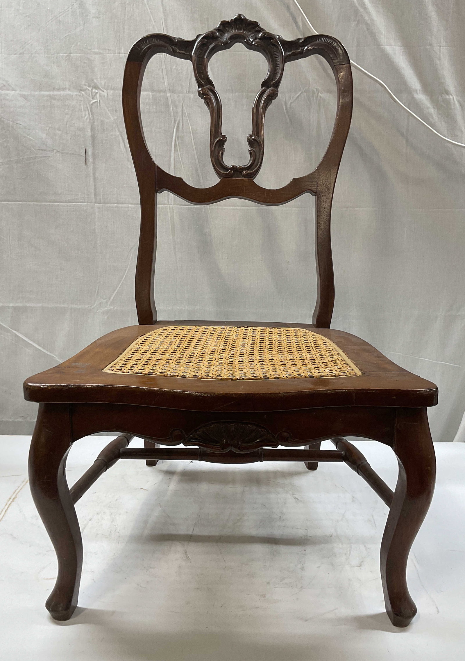 Antique parlor slipper chair: Antique parlor slipper chair, the top features a serpentine crest rail accented by central carvings. Directly beneath sits an openwork pierced vertical splat that forms a vase silhouette. Includes