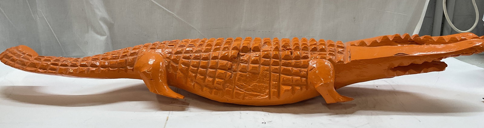 Hand carved folk art alligator sculpture: Hand carved folk art alligator sculpture. Piece is intricately hand carved from a single solid piece of wood. It features distinct chiseled notches that replicate the scales of an alligator. It is cov