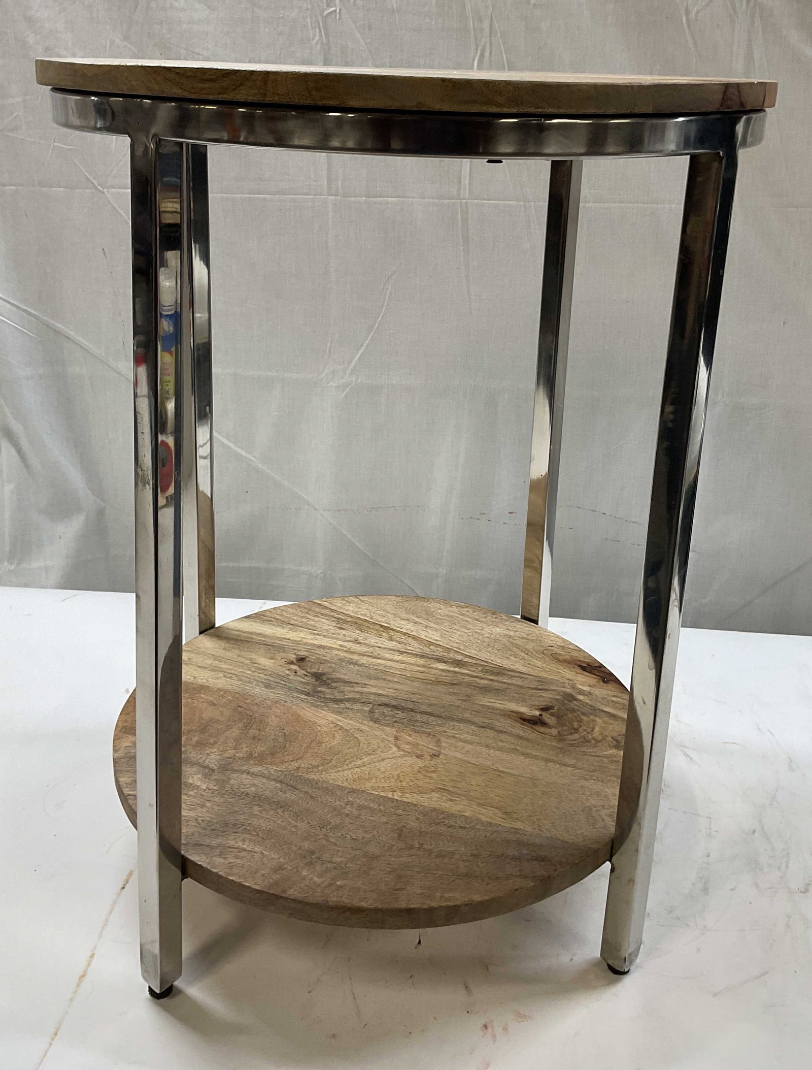 Wood and chrome two tier accent table: Wood and chrome two tier accent table. Features duel open shelves crated from natural multi toned wood paired with a heavy duty polished chrome frame. Built with 3 straight squared legs that seamlessl
