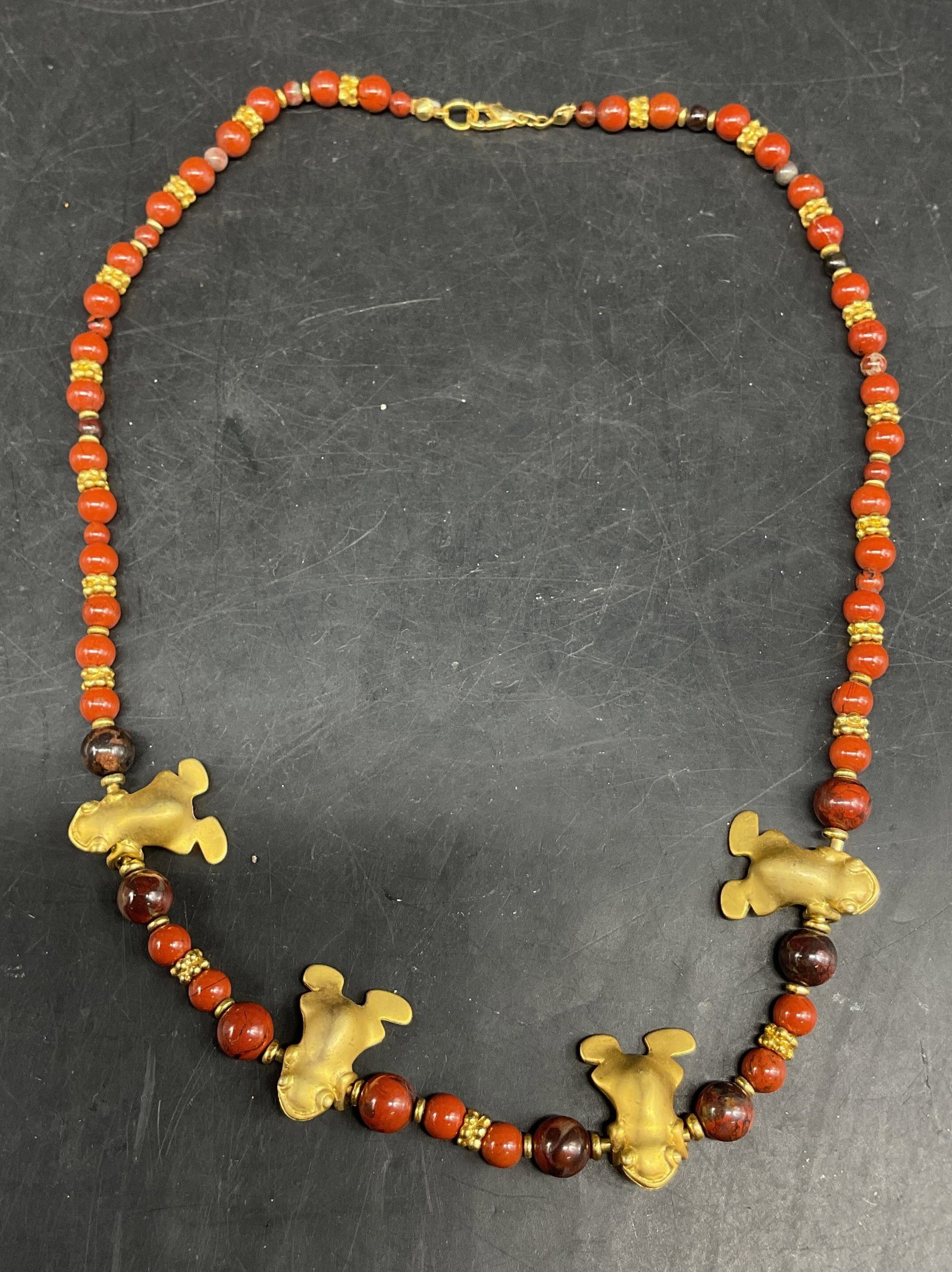 Vtg Gold Toned Semiprecious Frog Necklace: Vintage gold toned semiprecious gemstone frog necklace. Round orange and red semiprecious gemstones. Tested with Presidium Gem Tester II. Textured gold toned spacers. Four gold toned frog figures. Mea