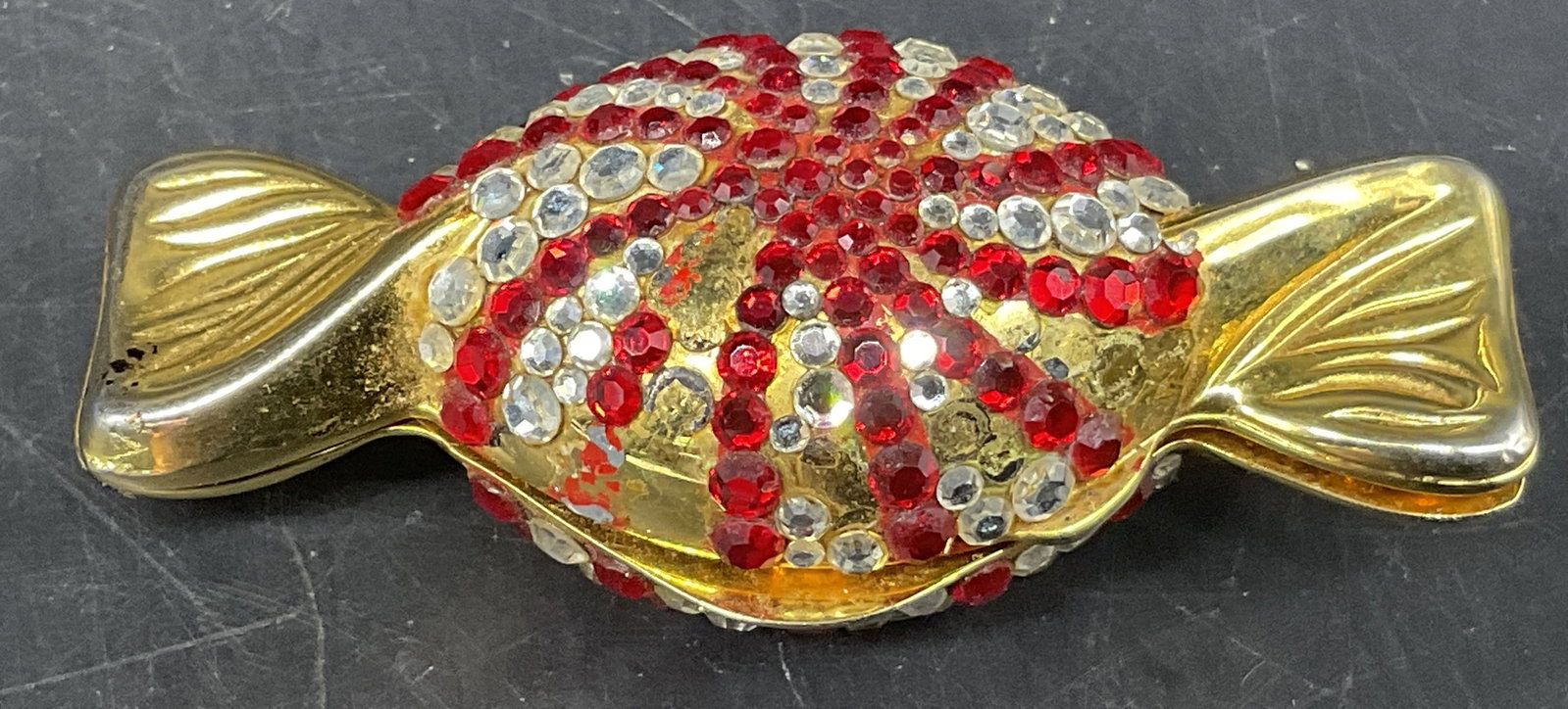 VTG Jeweled Peppermint Candy Pillbox ITALY: Vintage Wrapped Peppermint Candy Pillbox. Gold-Toned with red and white rhinestones. Italy. Missing stones. Some included. Some scratching and loss to coating. Measures approx 2.5in L. vintage