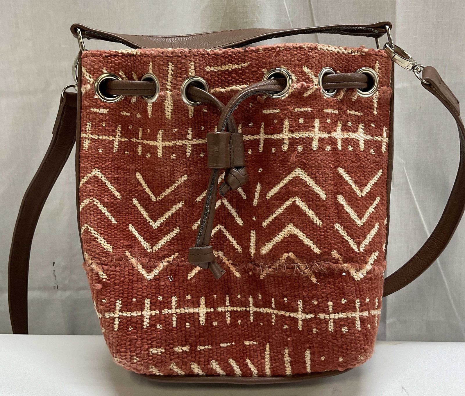 Vintage Woven Orange & White Crossbody Bag: Vintage woven orange and white crossbody bag. Geometric pattern. Attached straps. Interior compartments. Measures approx 9.5 x 10 inches. Surface wear consistent with exposure. Crossbody bag, bag,