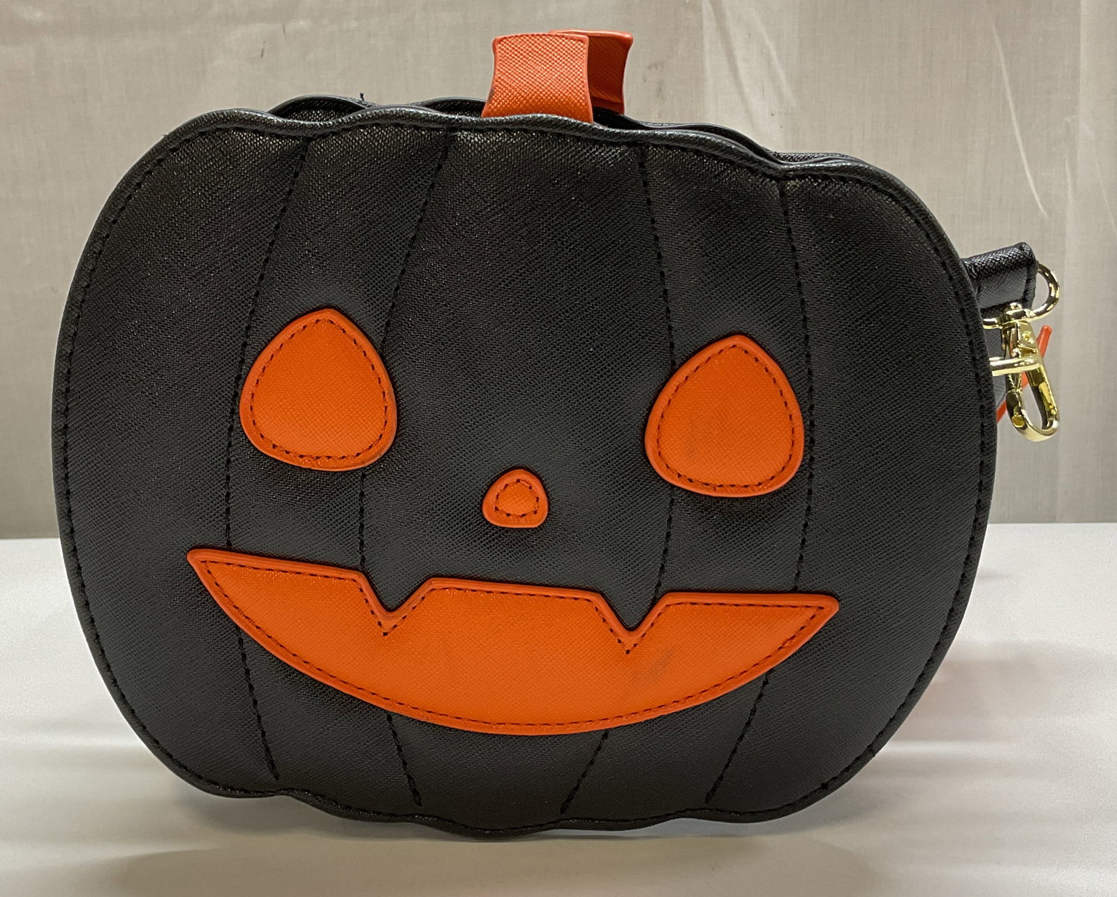 Vtg Black & Orange Halloween Pumpkin Crossbody Bag: Vintage black and orange Halloween pumpkin crossbody bag. Attached strap with buckle design and orange bat motifs. Bag is shaped like a pumpkin, jack o lantern, features eyes nose mouth in orange.