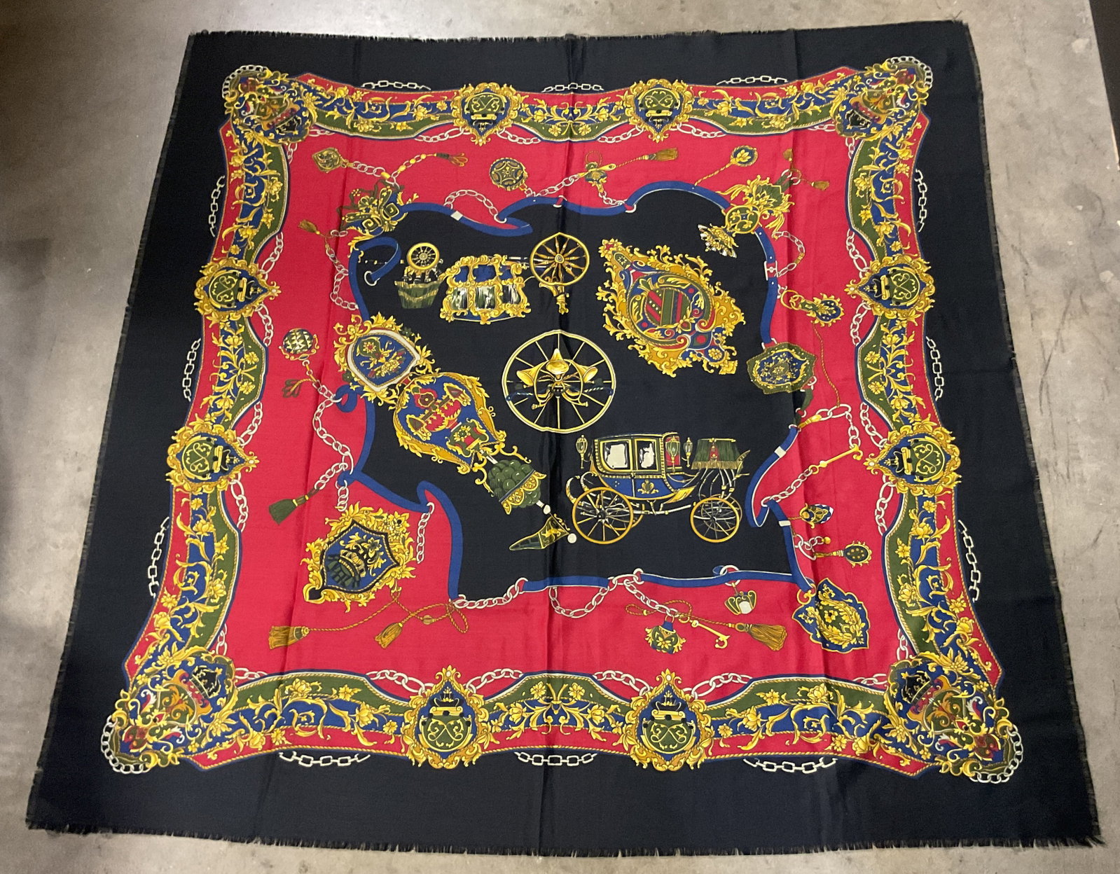 Vintage Red & Black Motif Fringed Scarf Italy: Vintage red and black motif fringed scarf. Made in Italy. Black fringed trim. Red, black, blue, yellow, etc. Floral and scroll motifs. Features horse drawn carriages, chains, ornate crests and more.