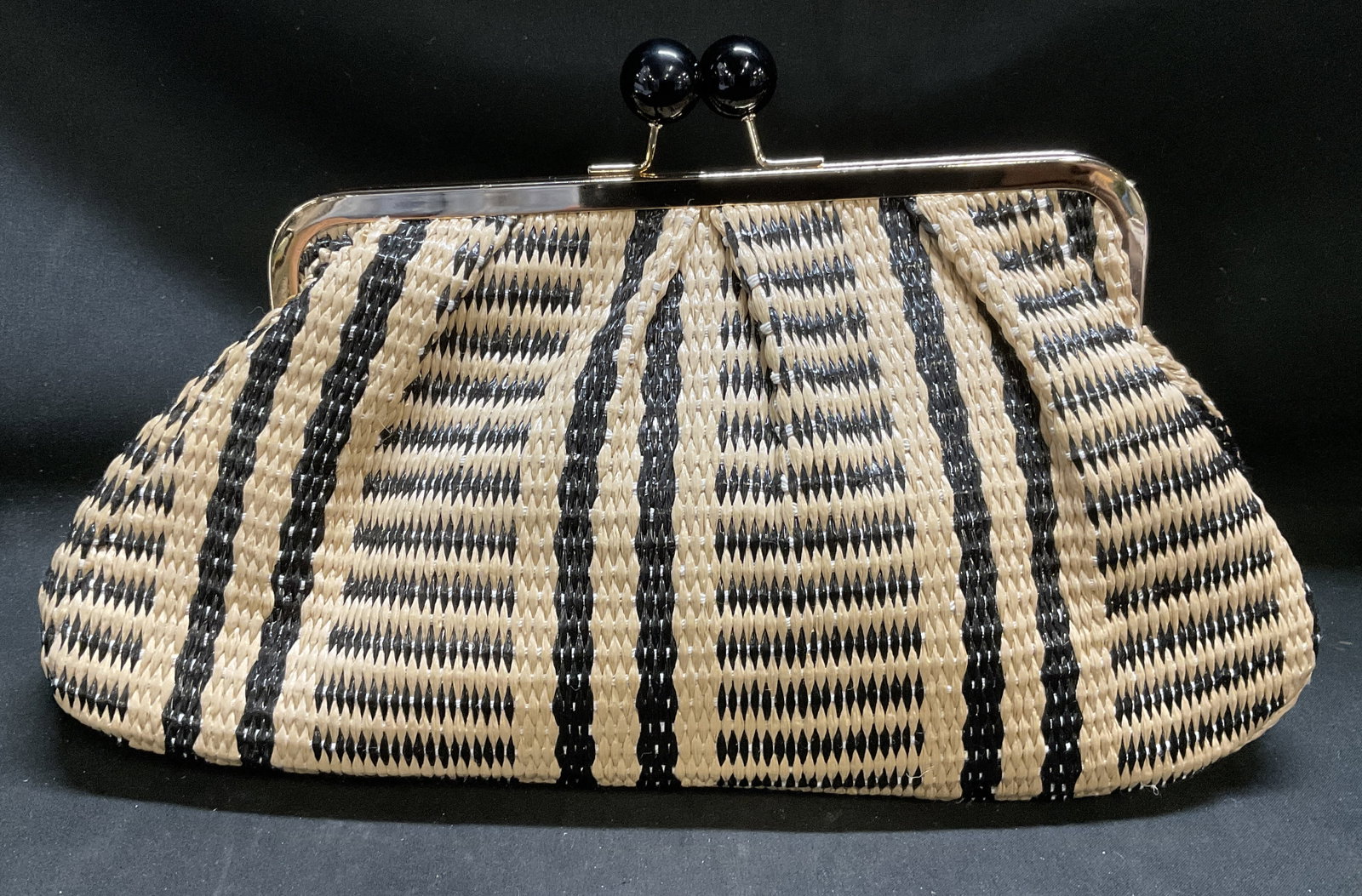 Boho-Style Contrast Striped Woven Dumpling Clutch: Bohemian-Style Black and Tan Striped Woven Dumpling Clutch. Vintage-Inspired pleated frame. Dual oversized black resin ball kiss-lock clasp. Condition consistent with age and exposure. Measures approx