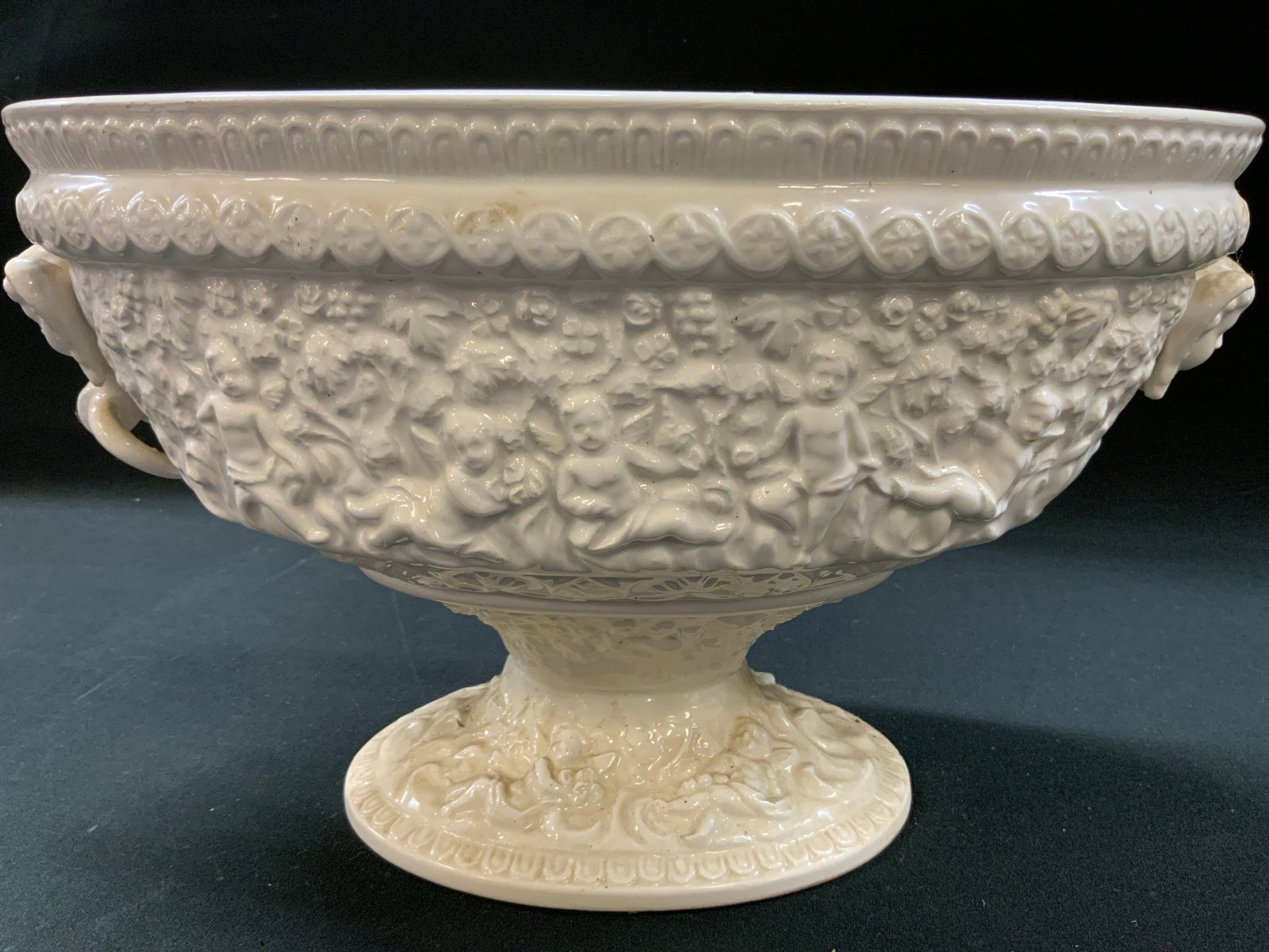 Vtg Ardalt Ceramic Cherub Relief Urn Bowl, Japan: Vintage white ceramic cherub relief pedestal urn bowl. Centerpiece bowl. High relief embossed band around the body depicting classical cherubs, putti, and grapevine motifs. Cherub busts as handles. Co