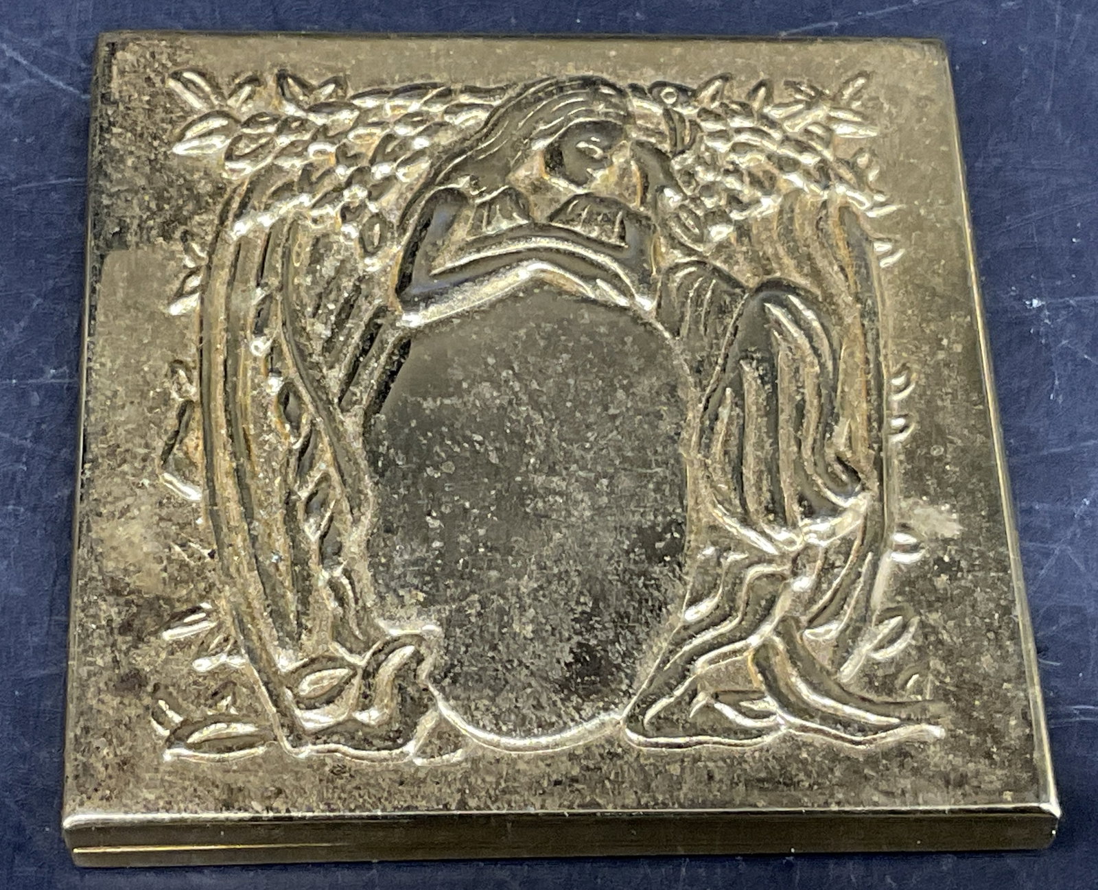 Art Nouveau-Style Gold-Toned Pocket Mirror: Art Nouveau-Style Gold-Toned Pocket Mirror. Raised, embossed design of classical woman with flowing hair surrounded by botanical motifs. Scratching, aging to metal, and coating loss. Measures approx