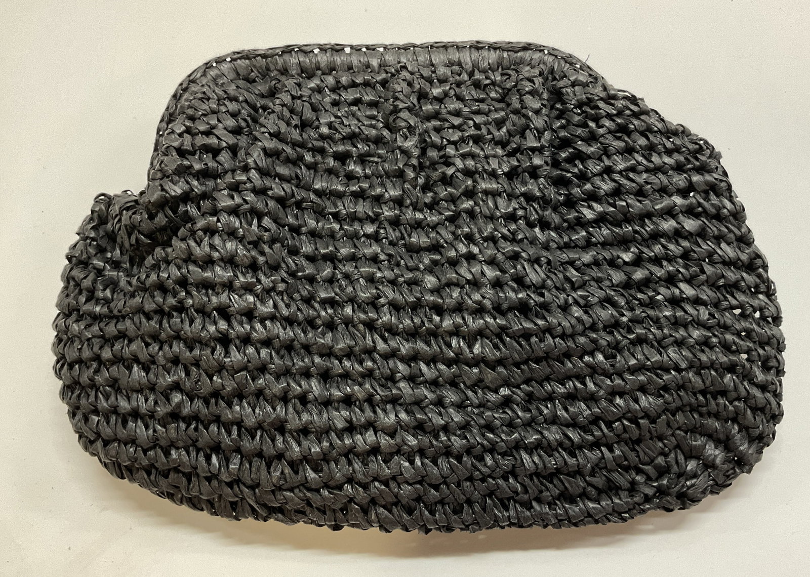 Hatattack Black Paper Straw Clutch: Hatattack black paper straw clutch. Outer material is 100% paper straw and the lining is 100% linen. Attached strap and magnetic button closure. Textured design. Interior compartments. Measures