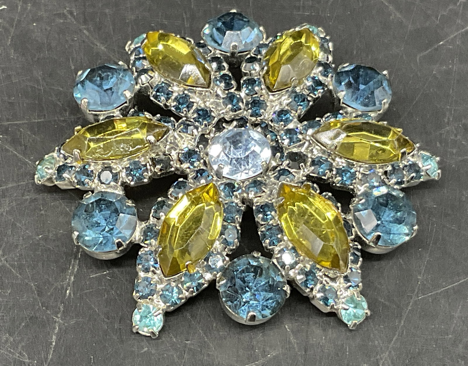 VINTAGE Floral Rhinestone Brooch: Vintage Silver-Toned Floral Rhinestone Brooch. Light green navette-cut rhinestones bordered by light blue chaton rhinestones and small cobalt blue rhinestones. Light blue center and edges. Condition