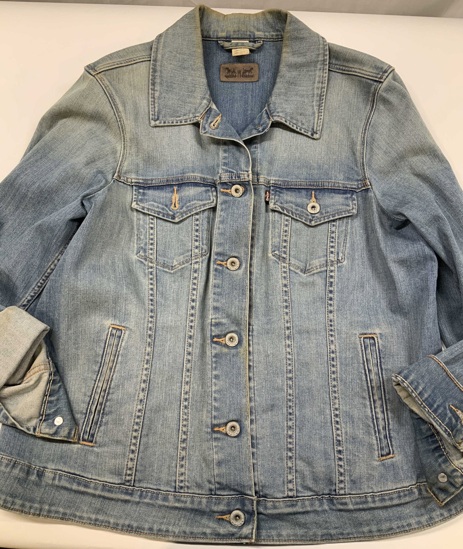 Vntg Levis denim jacket: Vintage Levi Strauss and Co denim jacket. Jacket has a rectangular brown faux leather patch centered below the collar. It features the famous Levis 2 horse pull logo. Also on the left chest pocket is 