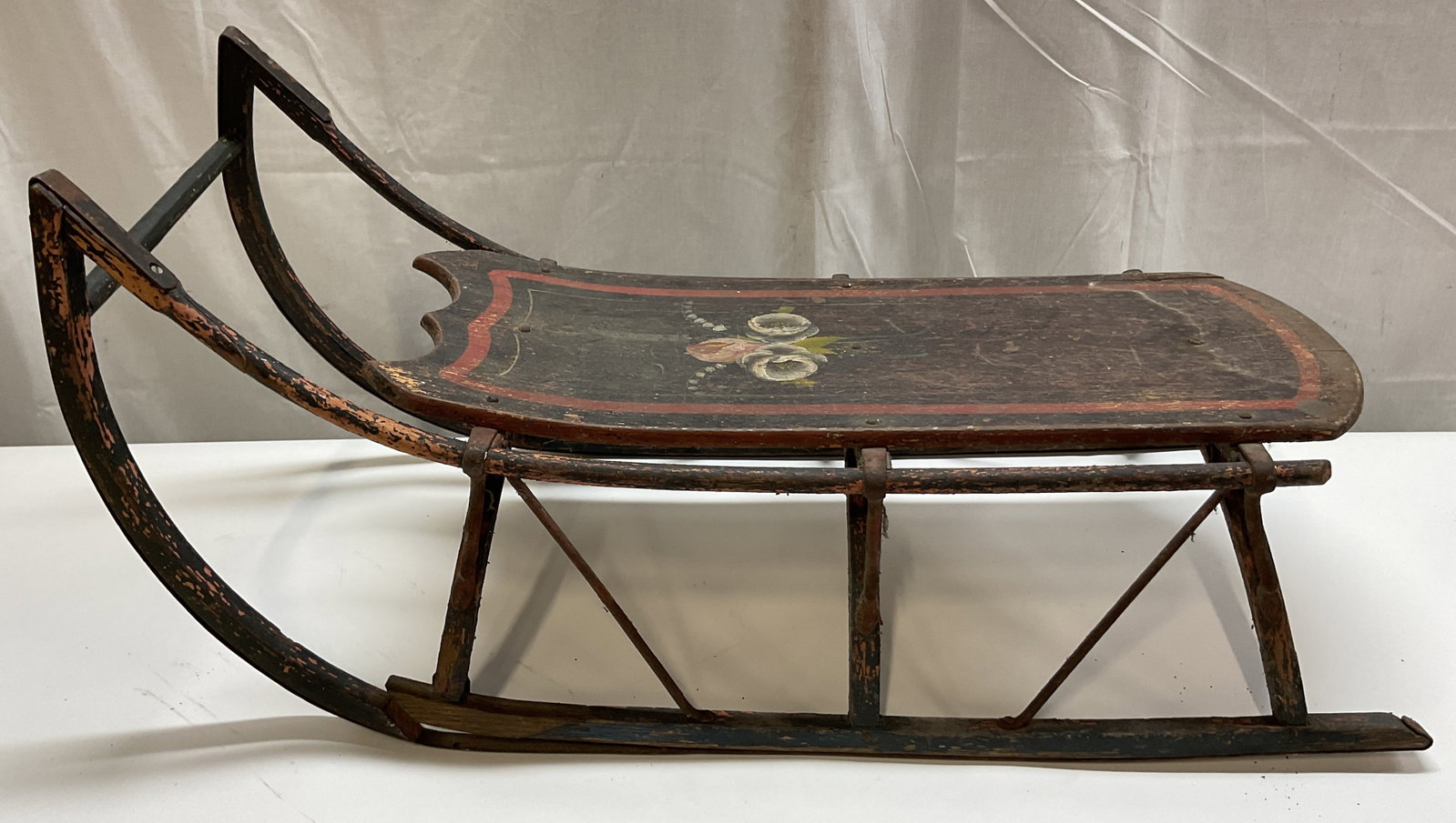 19th Century American Victorian Childs Snow Sled: 19th century American Victorian childs snow sled. Wooden. Bent swan neck frame. Dark platform with hand painted floral motifs in varying colors. Scalloped edge. Measures approx 11 x 30 x 14 inches. Ch