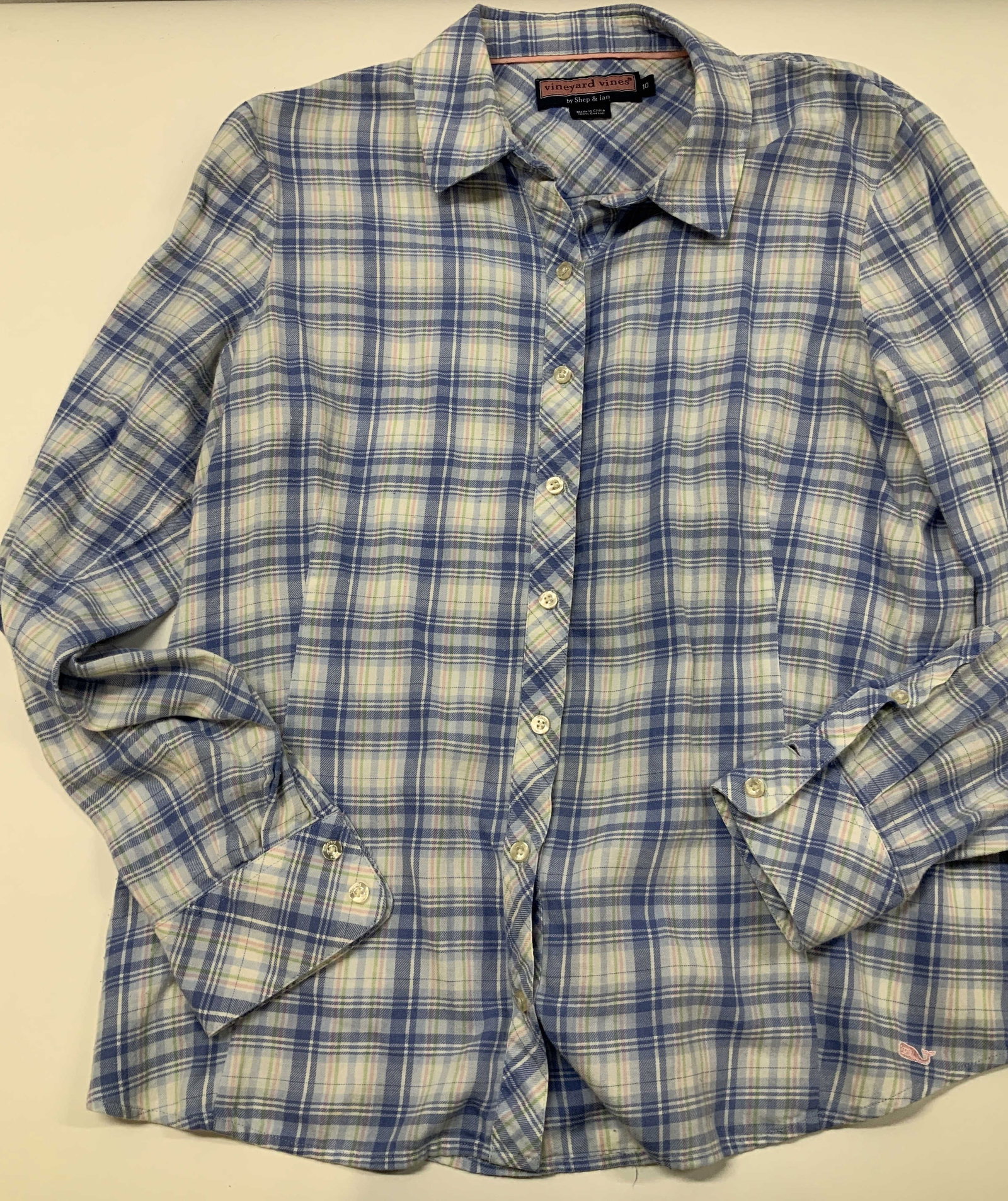 Vineyard Vines cotton plaid button up shirt: Vineyard vine plaid button up shirt. Made of 100% cotton in size 10. Shirt features a sublet pink whale logo near the bottom hem. Designed with a center button up closure, pointed collar, and cinched 