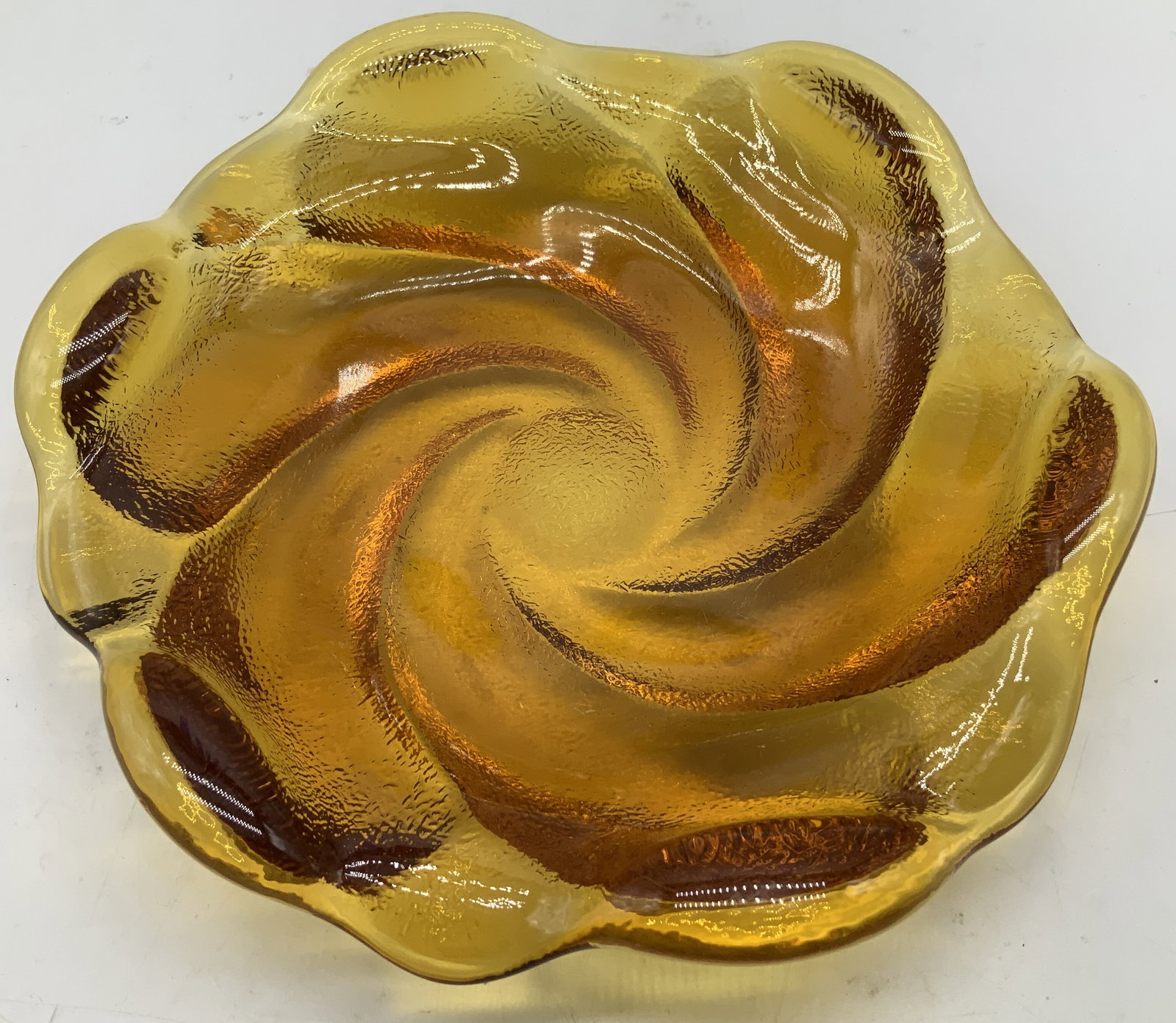 Mid Century Modern Amber Swirl Glass Dish: Mid Century Modern amber glass dish features a distinctive swirl pattern. Scalloped rim. No visible signature or markings. Surface wear consistent to age, use & exposure. Measurements: length 8.2in x 