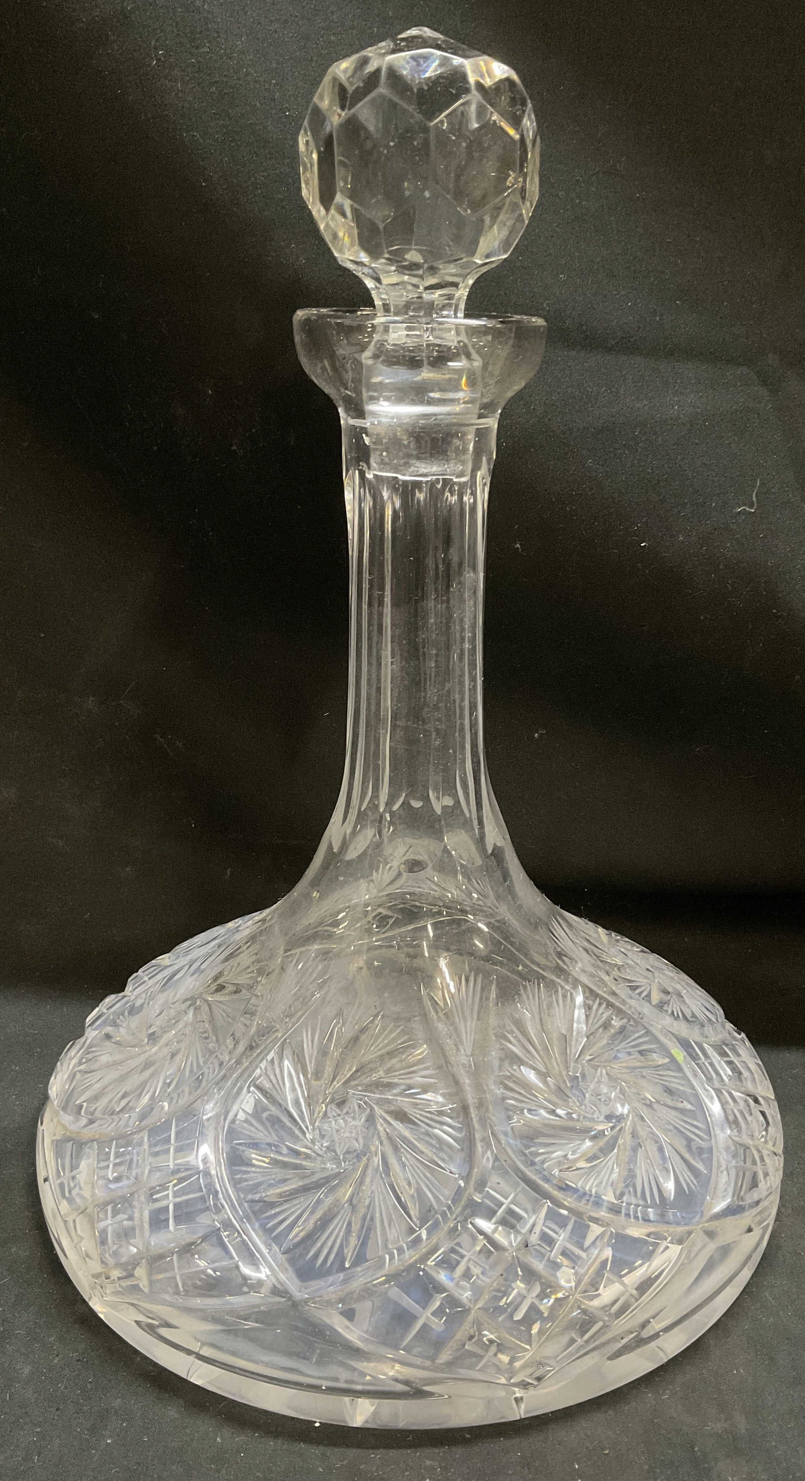VINTAGE Heavy Cut Crystal Ships Decanter: Vintage Heavy Clear Cut Crystal Ships Decanter. Pinwheel and fan patterns. Wide flat base. Faceted geometric stopper. Has significant weight. Chips on stopper. 11 in tall with stopper by 8 in in diame