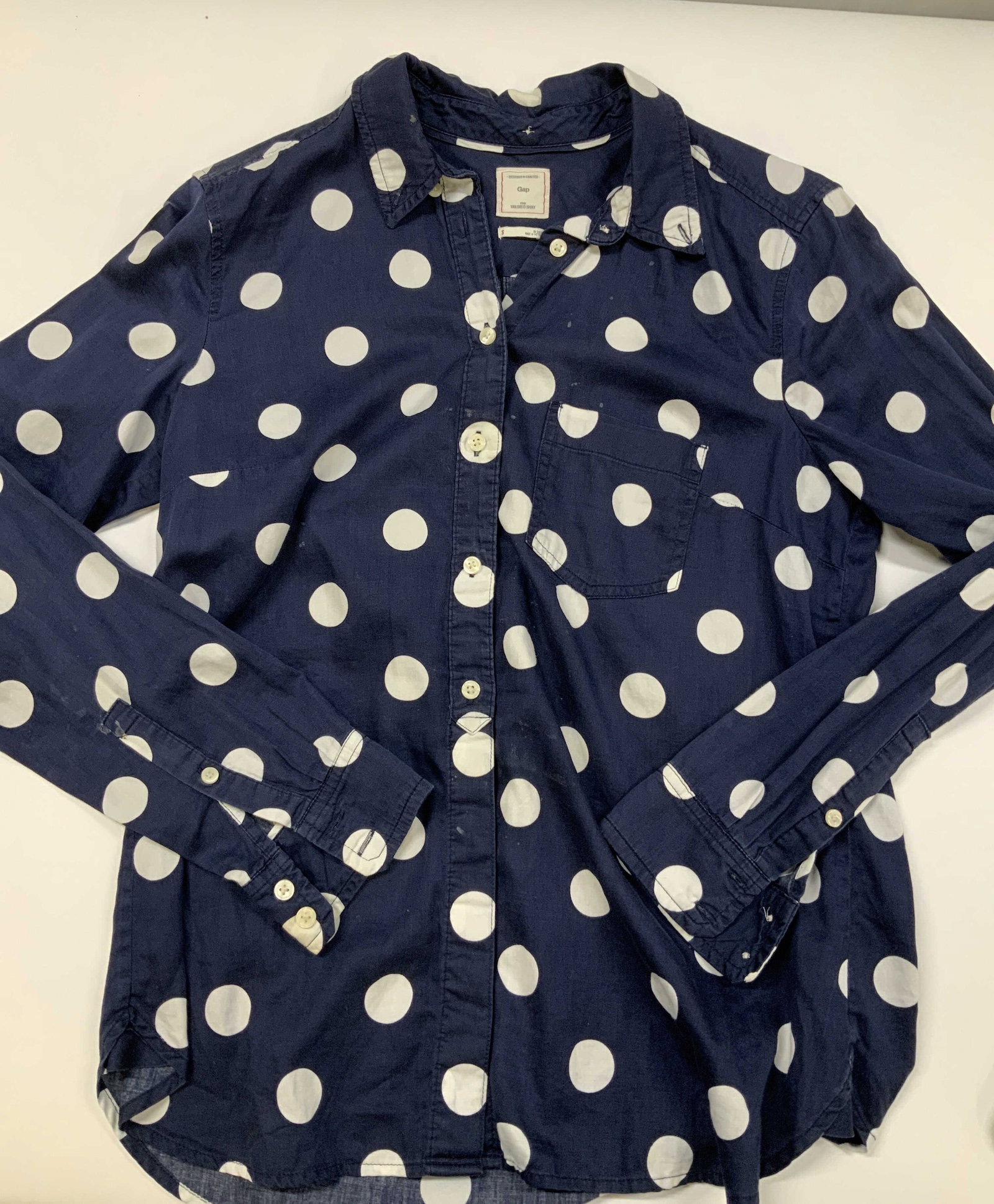 Gap cotton polka dot tailored button down shirt: Gap polka dot tailored button down shirt. Made of 100% cotton in size small. Tailored with a curved shirttail hemline, making it look clean weather tucked or untucked. Outfitted with glossy white comp
