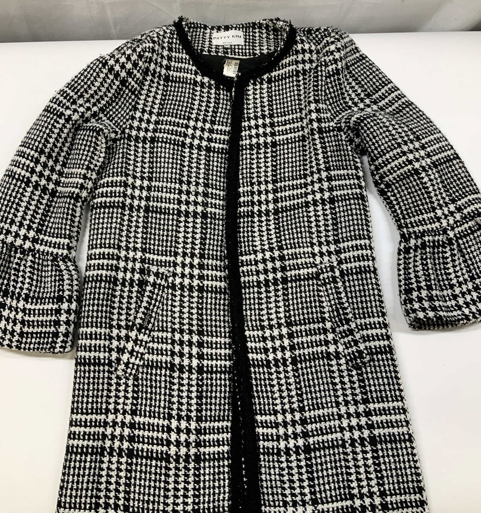 Patty Kim New York houndstooth open coat: Patty Kim New York houndstooth open coat. Made of a wool polyester blend in size medium. Classic black and white plaid houndstooth design. Crafted with an open front closure, clean collarless neckline