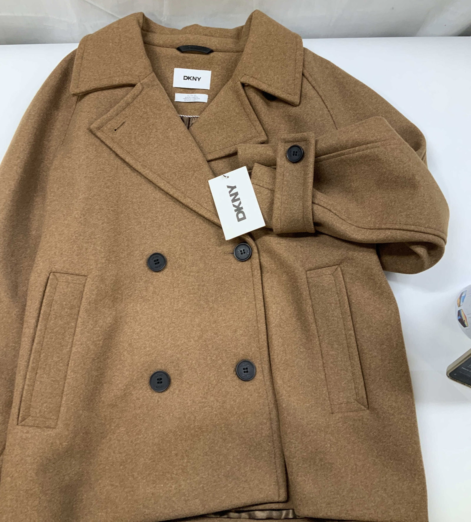 DKNY double breasted cropped coat, CambodiaNWT: DKNY double breasted cropped coat. New With Tags. Made in Cambodia in size XL. A tailored shorter length peacoat silhouette featuring double breasted button closure and exaggerated notched lapels. It 