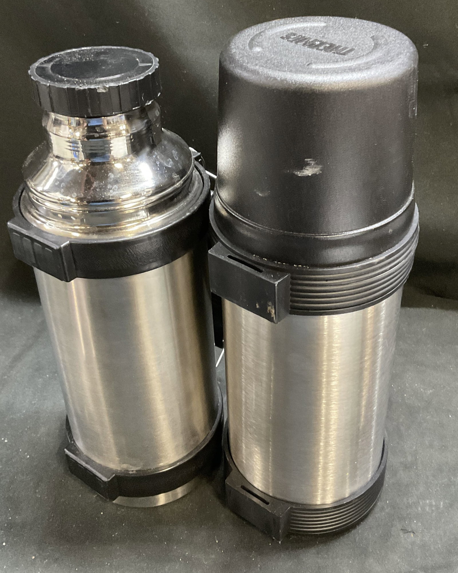 Lt2 VTG Thermos+ Stainless Steel Insulated Bottles: 2 Vintage Stainless Steel Vacuum Insulated Bottles. One Thermos brand with cap. Both with side handles. Tallest Measures approx 11.5in H x 4in Diam. vintage, stainless steel, bottles, camping, travel,