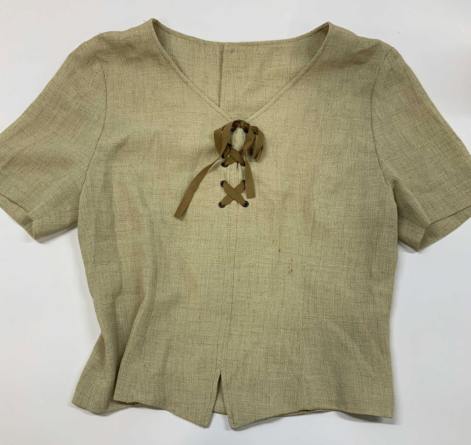 Textured lace up top: Textured lace up top. Showcases a characteristic slubbed texture with visible organic cross hatch weaving. A neutral earthy beige color that matches effortlessly to summer basics. Deep v nick trimmed