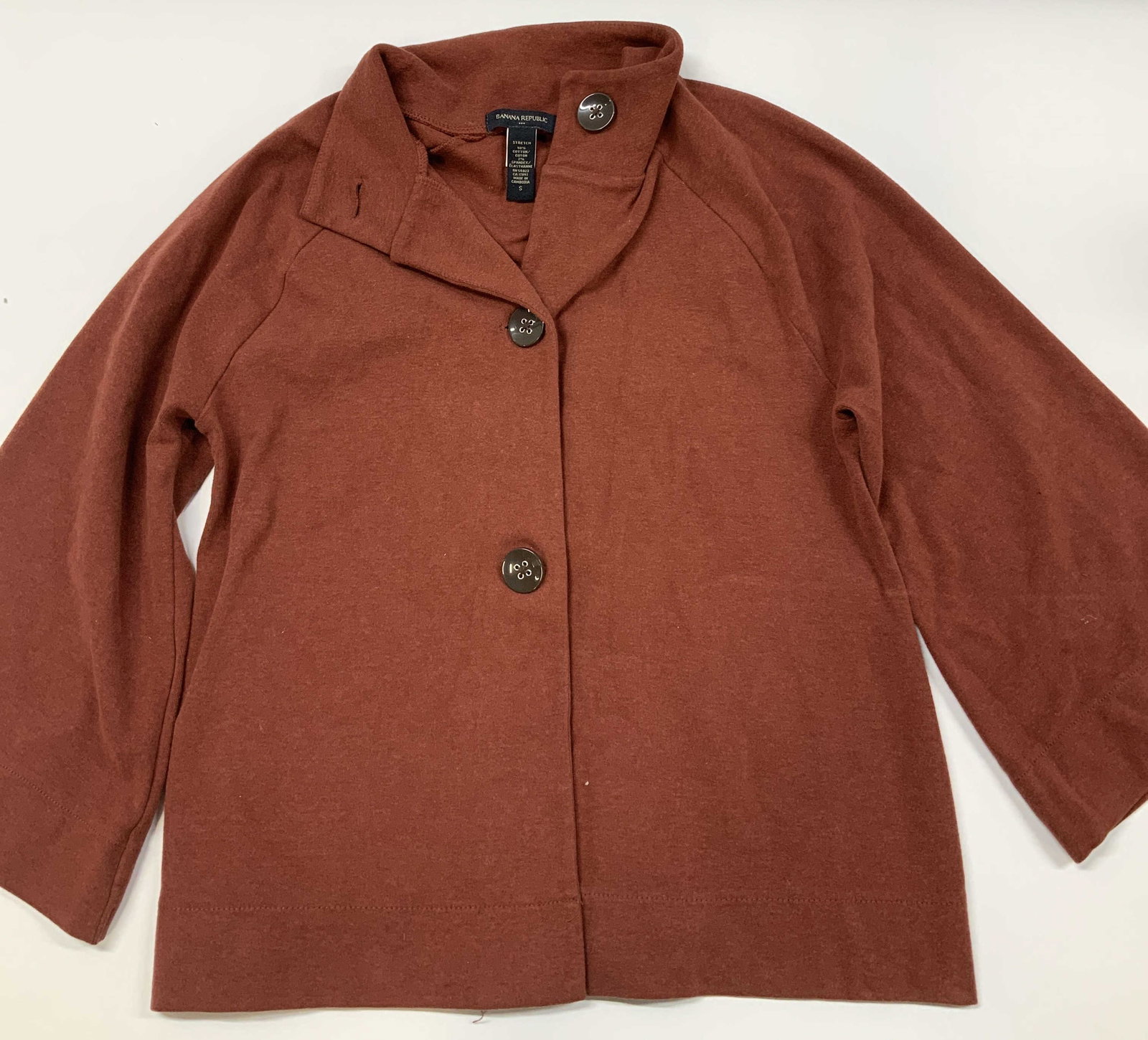 Banana Republic button front cardigan, Cambodia: Banana Republic button front cardigan. Fabric is a rich burnt orange color. Made in Cambodia of a cotton spandex blend in size small. Styled with an adaptable structured fold over collar. Features