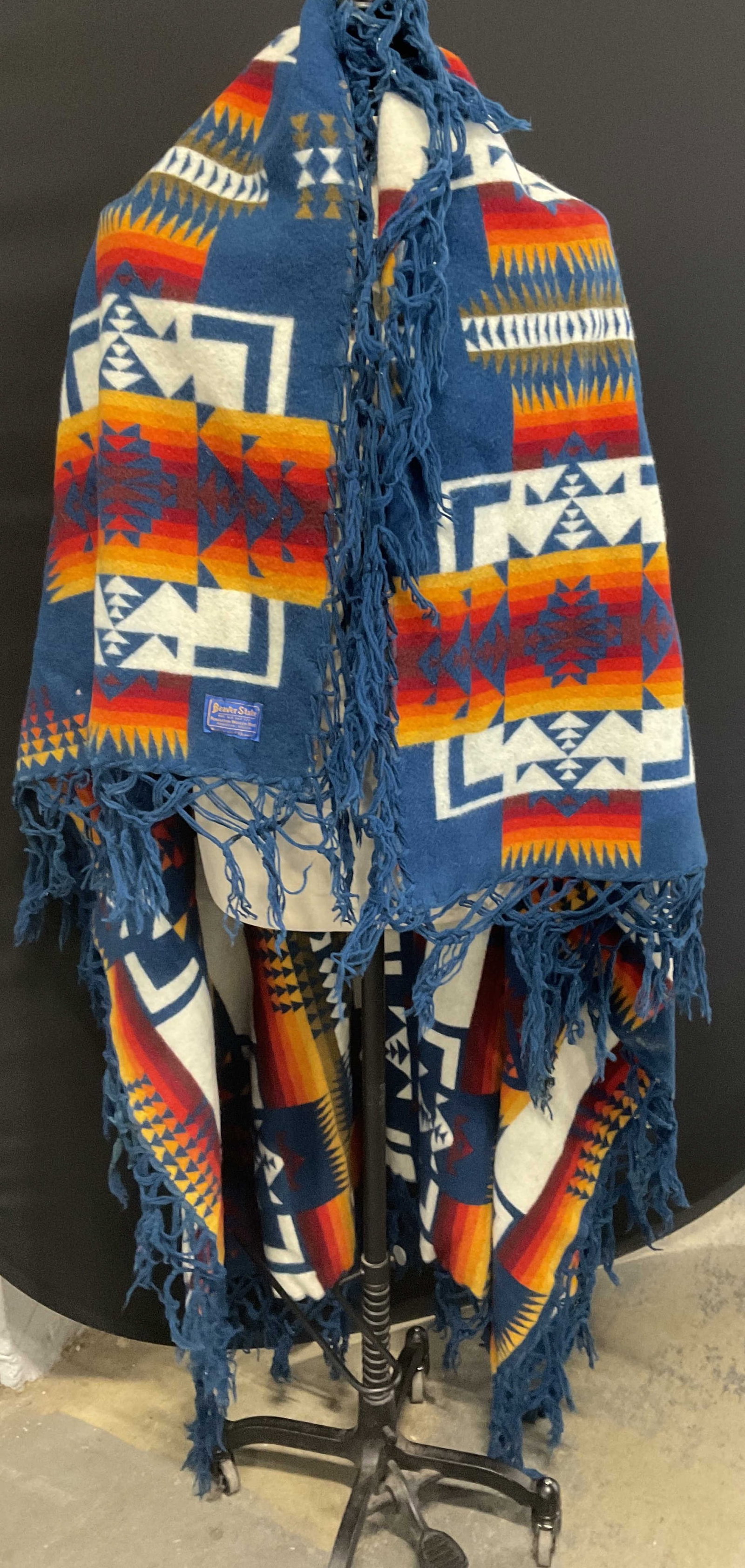 VTG Beaver State Native American Insp Wool Shawl: Vintage Beaver State Native American Inspired Wool Shawl. Oregon. Colorful orange, red, blue, yellow, and brown geometric patterns. Blue fringed edges. Some staining, fraying, and tears. Measures