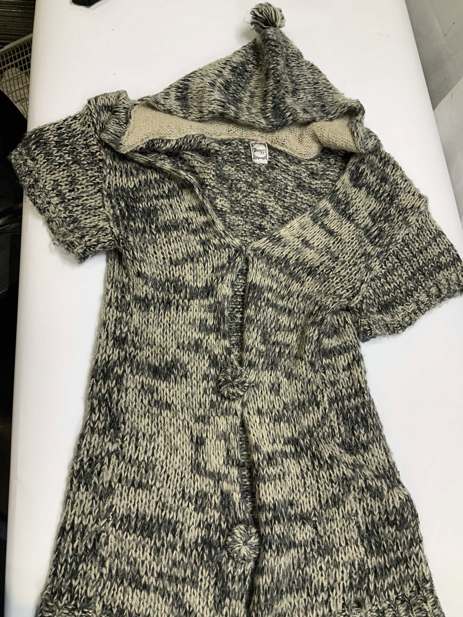 Vntg Banana USA Chunky knit hooded cardigan: Vintage Banana USA Chunky knit hooded cardigan. The attached hood features a sift cream contrast king and topped with decorative yarn pom pom. This piece features short sleeves unlike traditional