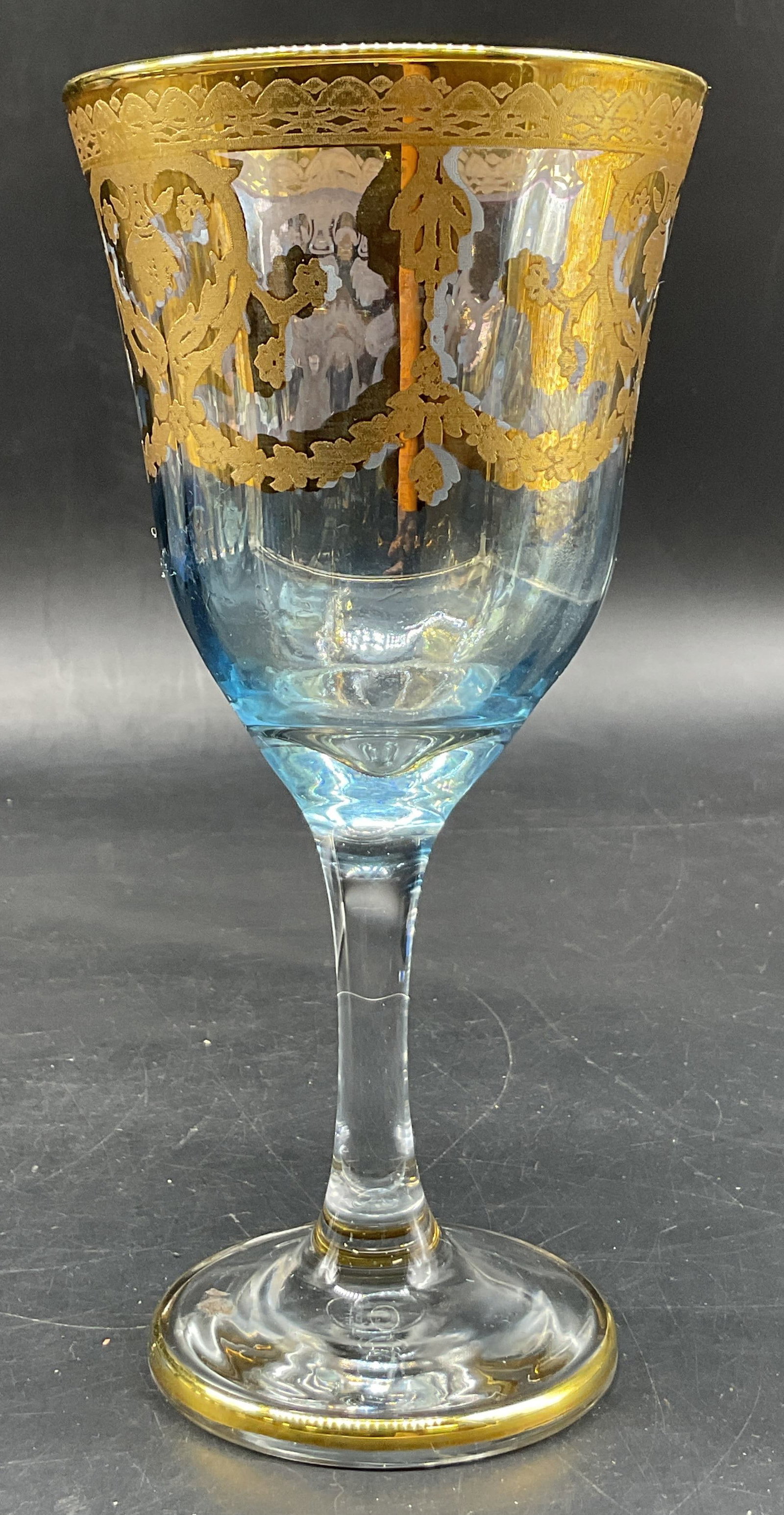 Vintage Blue & Gilt Glass Wine Goblet: Vintage blue and gilt glass wine goblet. Round base with gilt rim. Tall stem. Light blue with hand painted gilt scroll motifs. Measures ht approx 7 inches diam approx 3.5 inches. Scratching. Wine