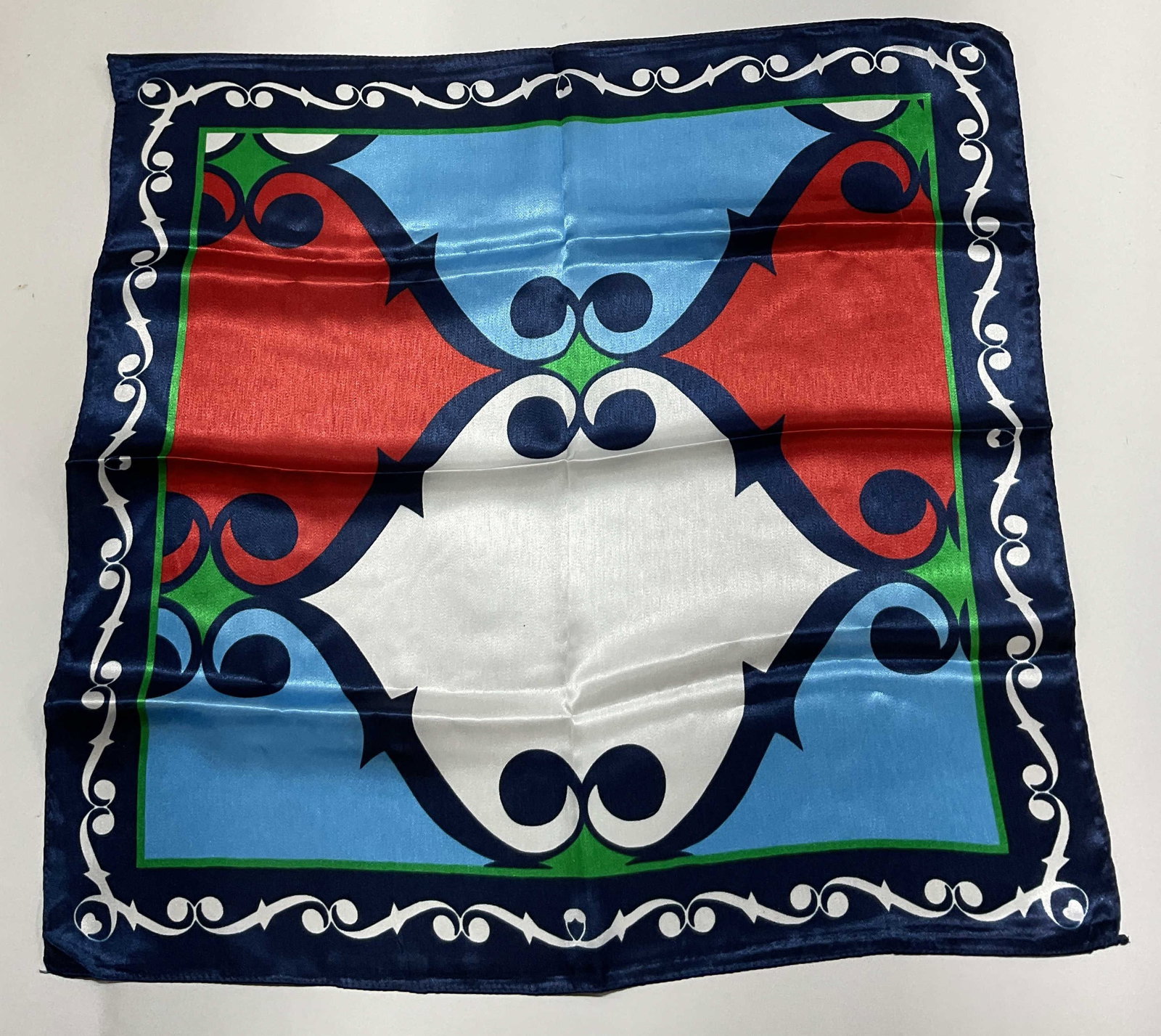 Vintage Multicolor Geometric Silk Scarf: Vintage multicolor geometric silk scarf. Ornate white scroll border. Geometric design in blue, red, and white with a green border. Measures approx 19 x 19.5 inches. Wear consistent with exposure. Scar