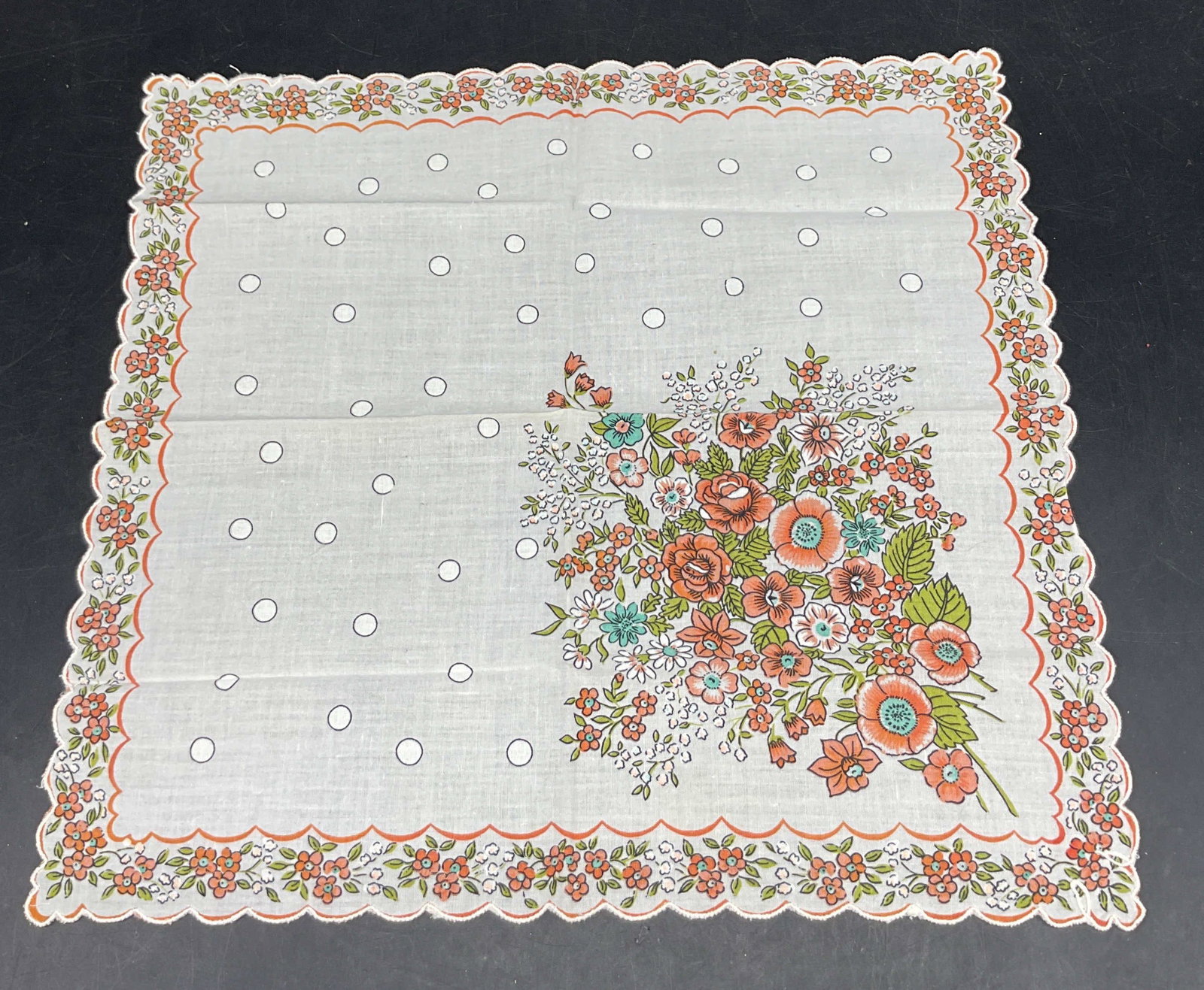 Vintage Scalloped Floral Linen Napkin: Vintage scalloped floral linen napkin. Orange and white scalloped trim. Floral motifs in orange, blue, green, and white. White and black dot pattern. Orange scalloped border. Measures approx 12.5 x 13