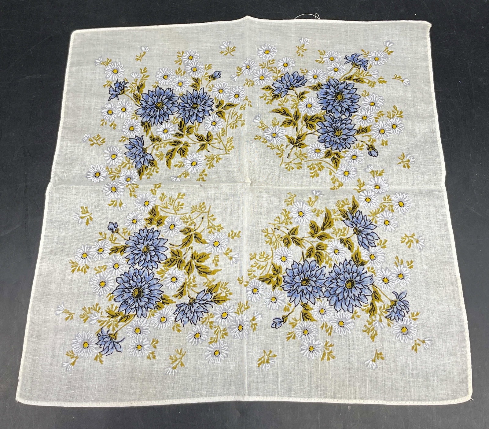 Vintage White Floral Linen Napkin: Vintage white floral linen napkin. Floral motifs in blue, green, yellow, and white. Measures approx 11.5 x 12 inches. Surface wear consistent with exposure. Napkin, linens, tableware, home decor, tabl