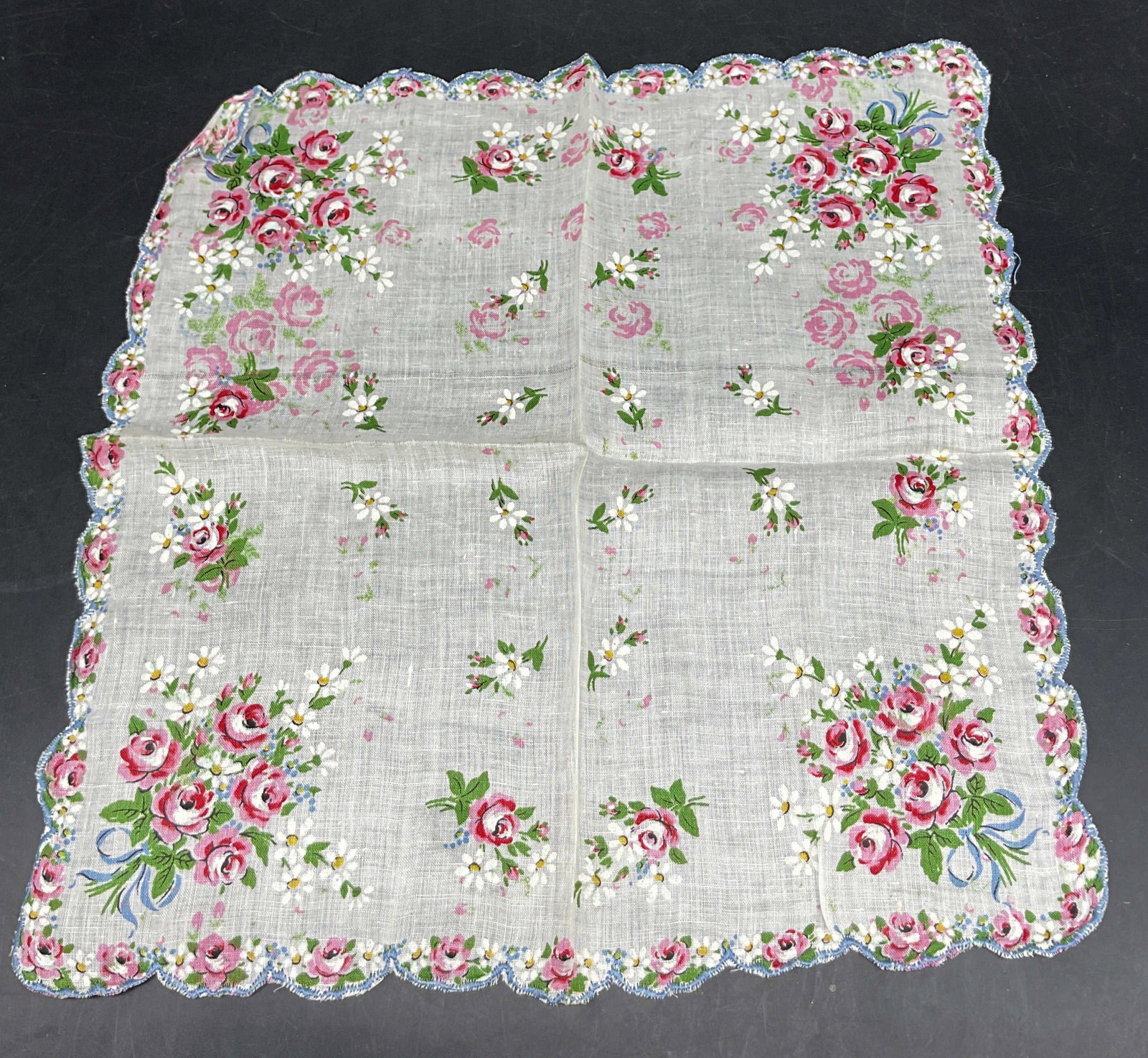 Vintage Scalloped Floral Linen Napkin: Vintage scalloped floral linen napkin. Blue scalloped trim. Floral bouquet motifs in green, pink, blue, white, yellow. Blue ribbon accent. Measures approx 12.5 x 13 inches. Surface wear consistent wit