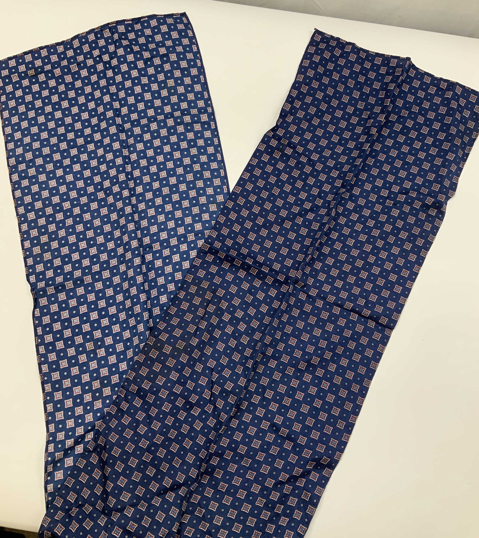 Vntg Tie Rack silk patterned scarf: Vintage Tie Rack patterned scarf. Made of 100% silk. Scarf features a geometric medallion pattern in red and white on a navy blue background. Scarf measures app 56 in long. Scarf, geometric, silk H 11