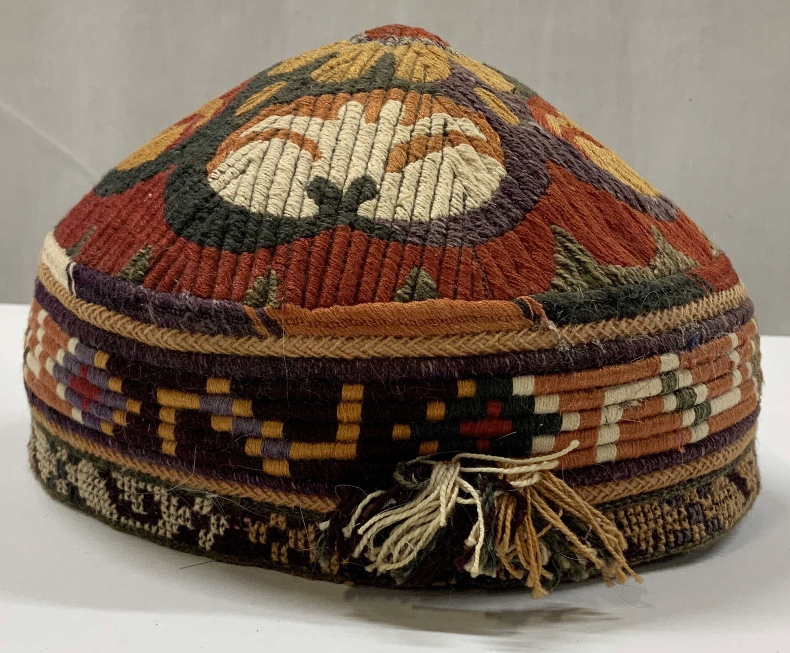 Vntg handmade central Asian tribal skullcap.: Vintage handmade central Asian tribal skullcap. Can also be called doppi, tubeteika, Toki, or tahiyah. The dense multi colored chains stitch embroidery utilizes traditional patterns. These geometric