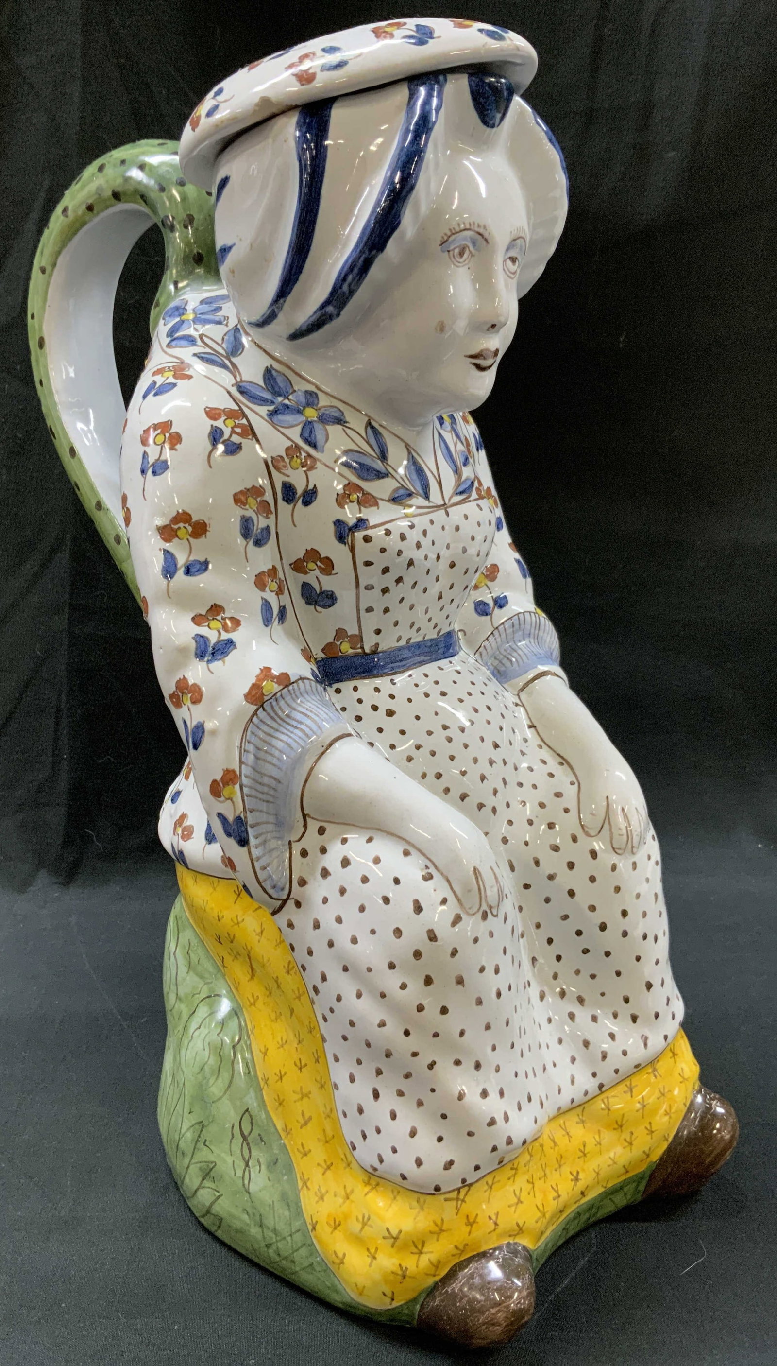 Vtg Majolica Lidded Character Lady Toby Jug: Vintage hand painted majolica earthenware lidded character Toby jug. Modeled as a stylized woman with folk costume featuring floral jacket, dotted apron, traditional bonnet, sitting atop green grassy 
