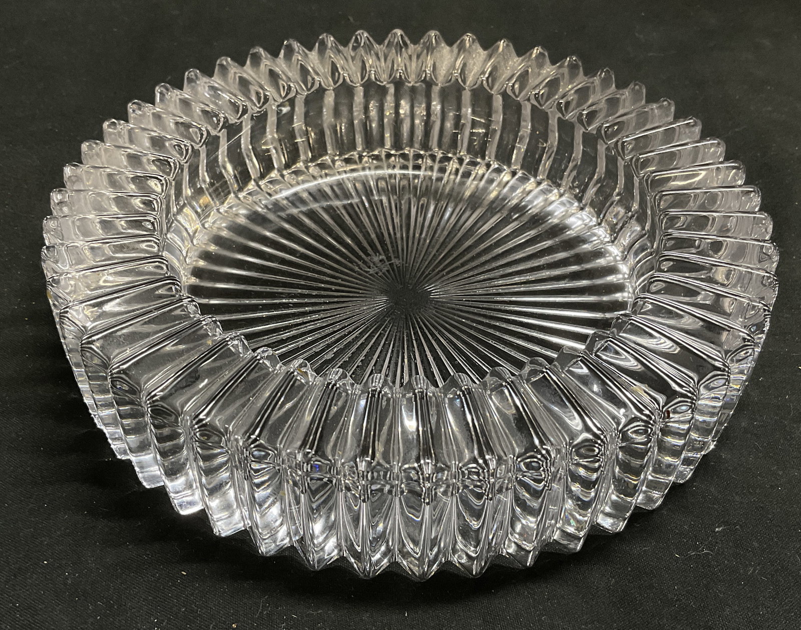 Mid-Century Modern Cut Crystal Round Ashtray: Mid-Century Modern Cut Crystal Round Ashtray. Sawtooth rim. Chunky prism cuts along walls. Sharp starburst pattern on base. Condition consistent with age and exposure. Measures approx 6in Diam. Mid-Ce