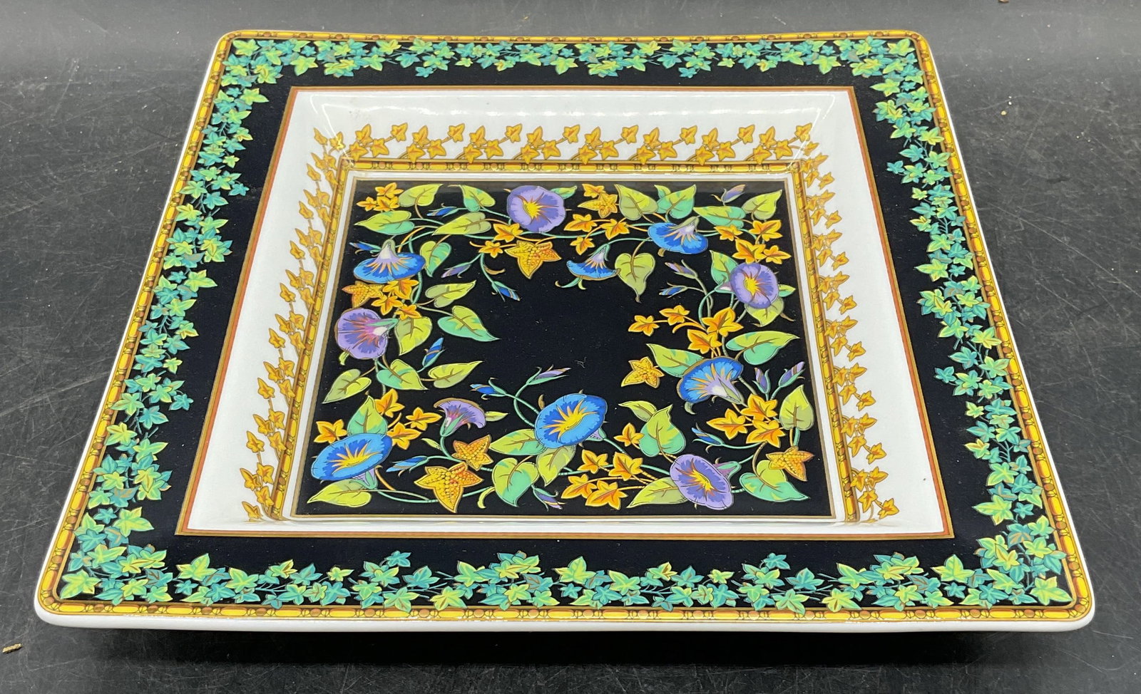 Rosenthal Versace Gold Ivy Porcelain Dish, Germany: Signed Rosenthal for Versace porcelain plate. Gold Ivy pattern. Square shaped dish. Intricate floral and vine pattern in black, green, and gold. Measures approx 8.75 x 8.75 x 1.25 inches. Made in Germ